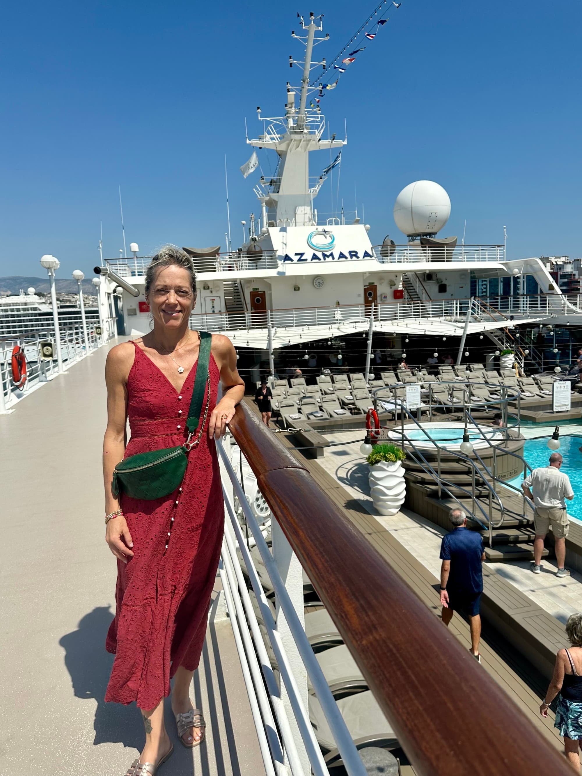 Travel advisor posing on board near the deck pool on a sunny day.