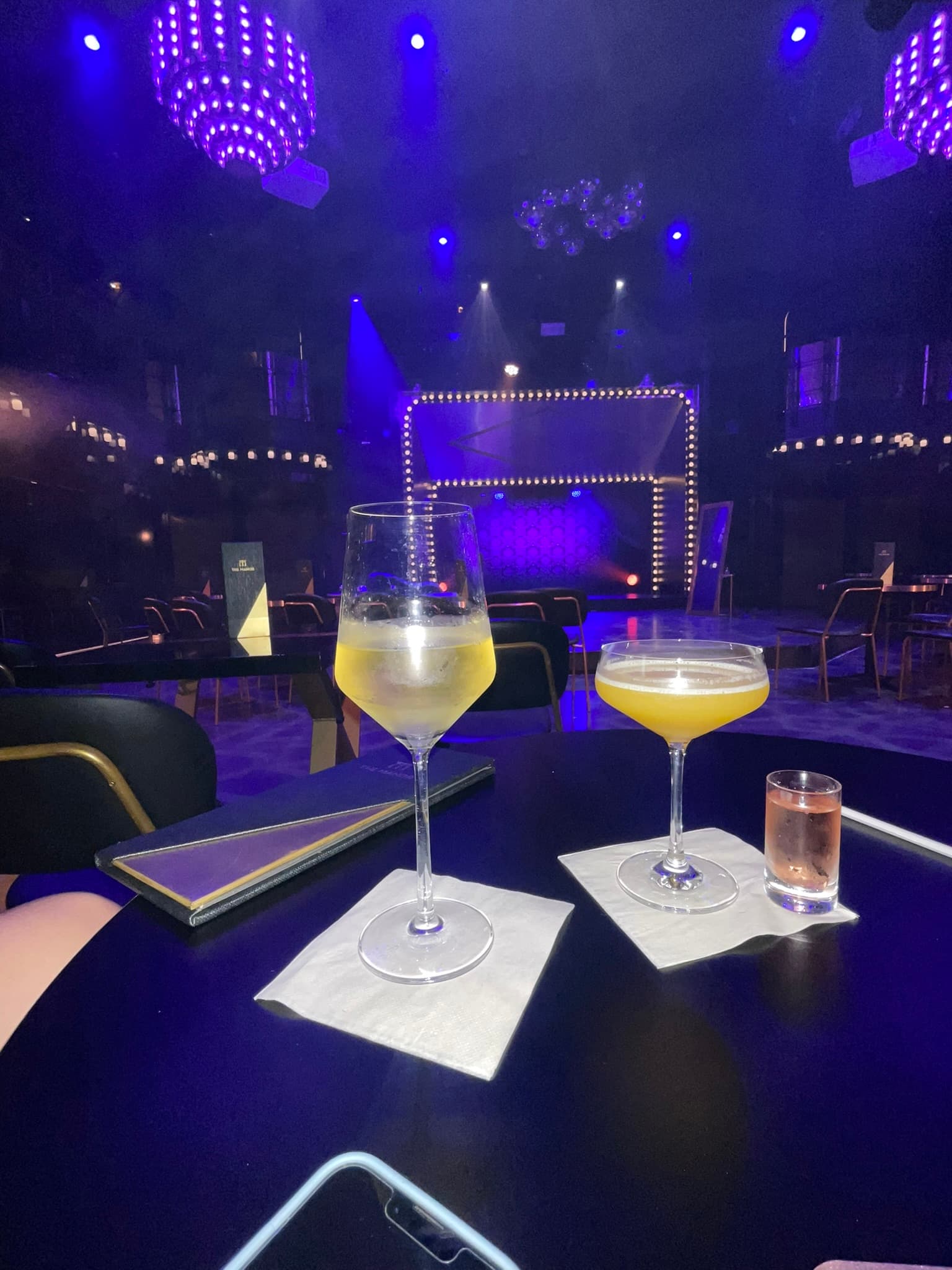 Drinks on a table in the entertainment room with purple lights.