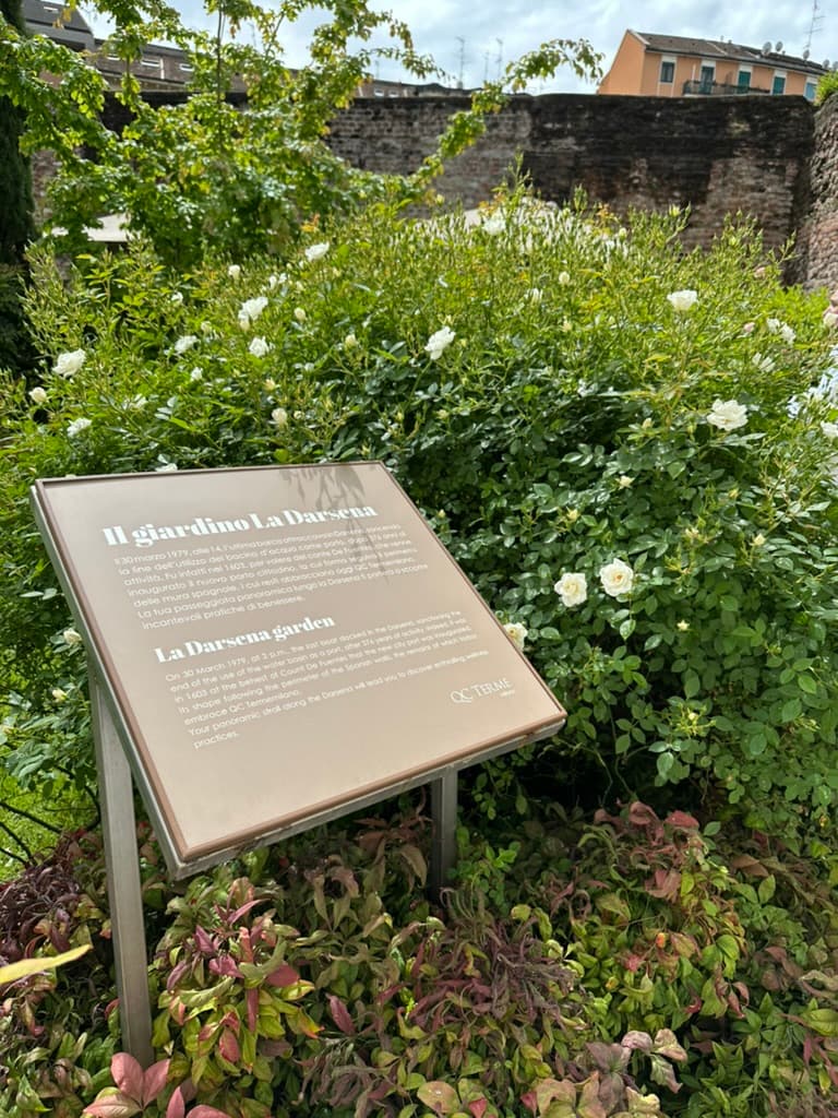 A description plaque in front of a flower bush