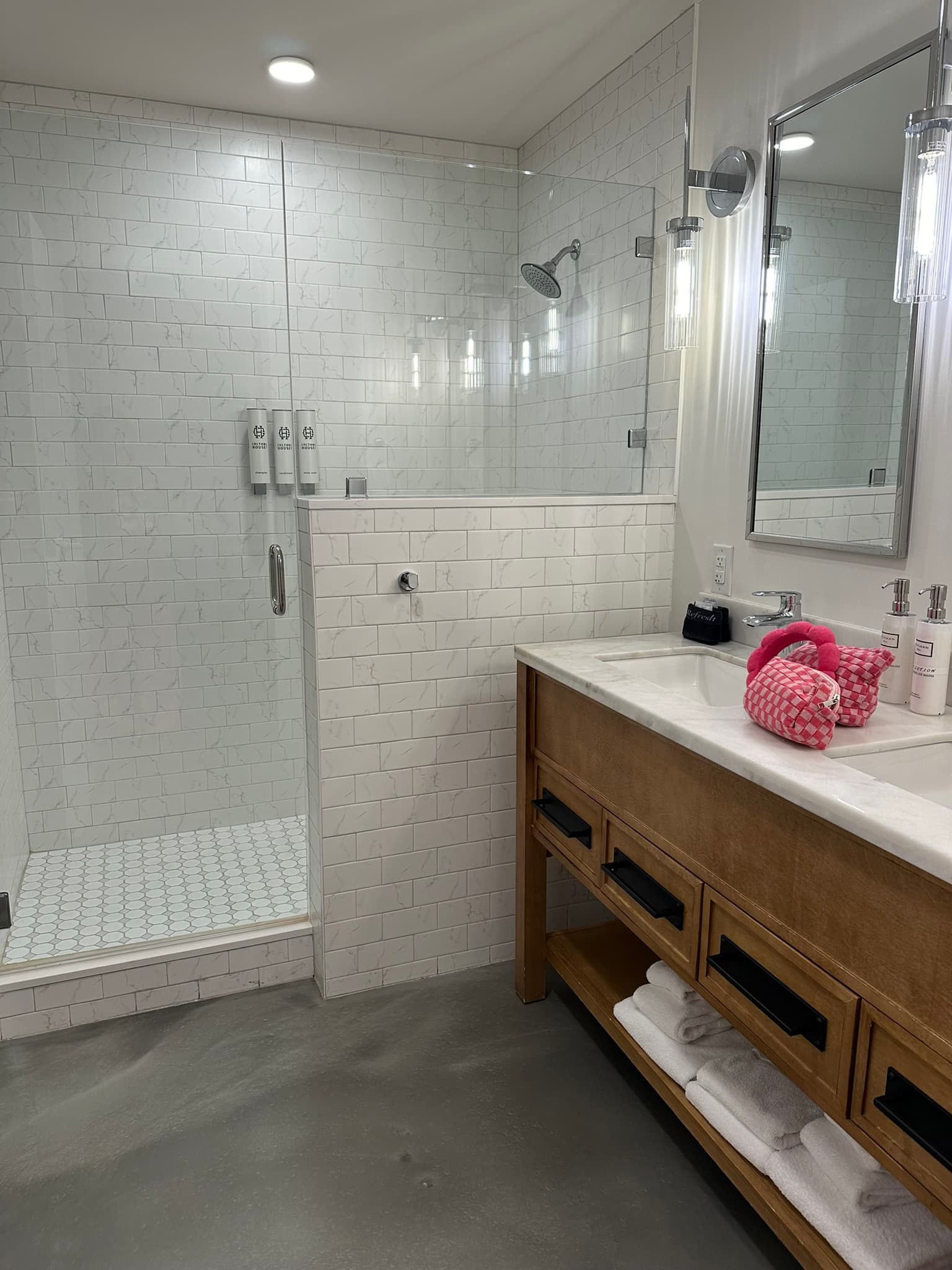 The studio bathroom features a large tiled shower and double sink.