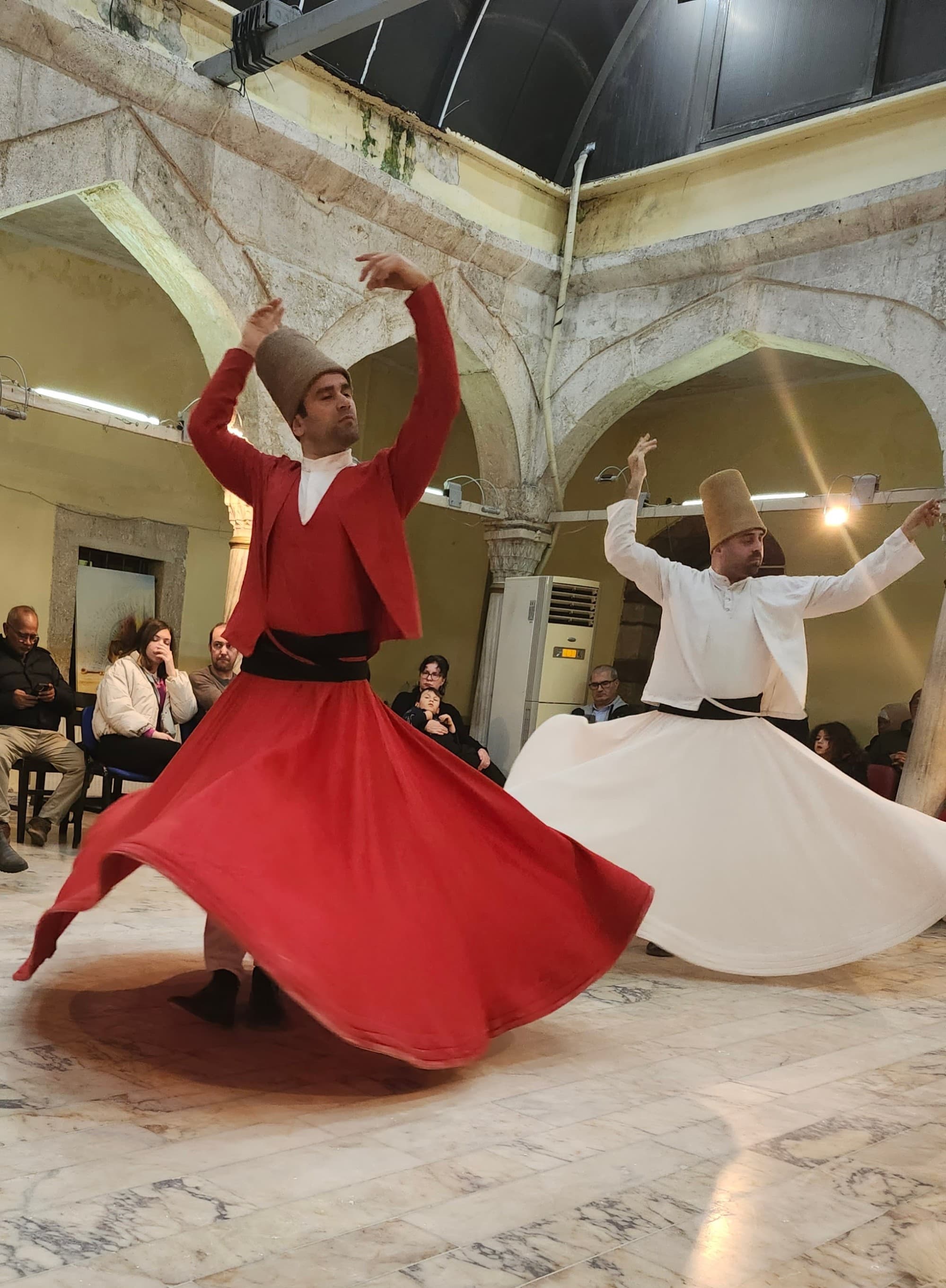 Two dancers in a room, one dressed in red, one in white