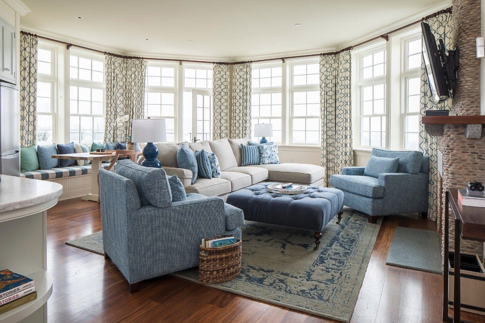 a New England living room with plush blue chairs and couches