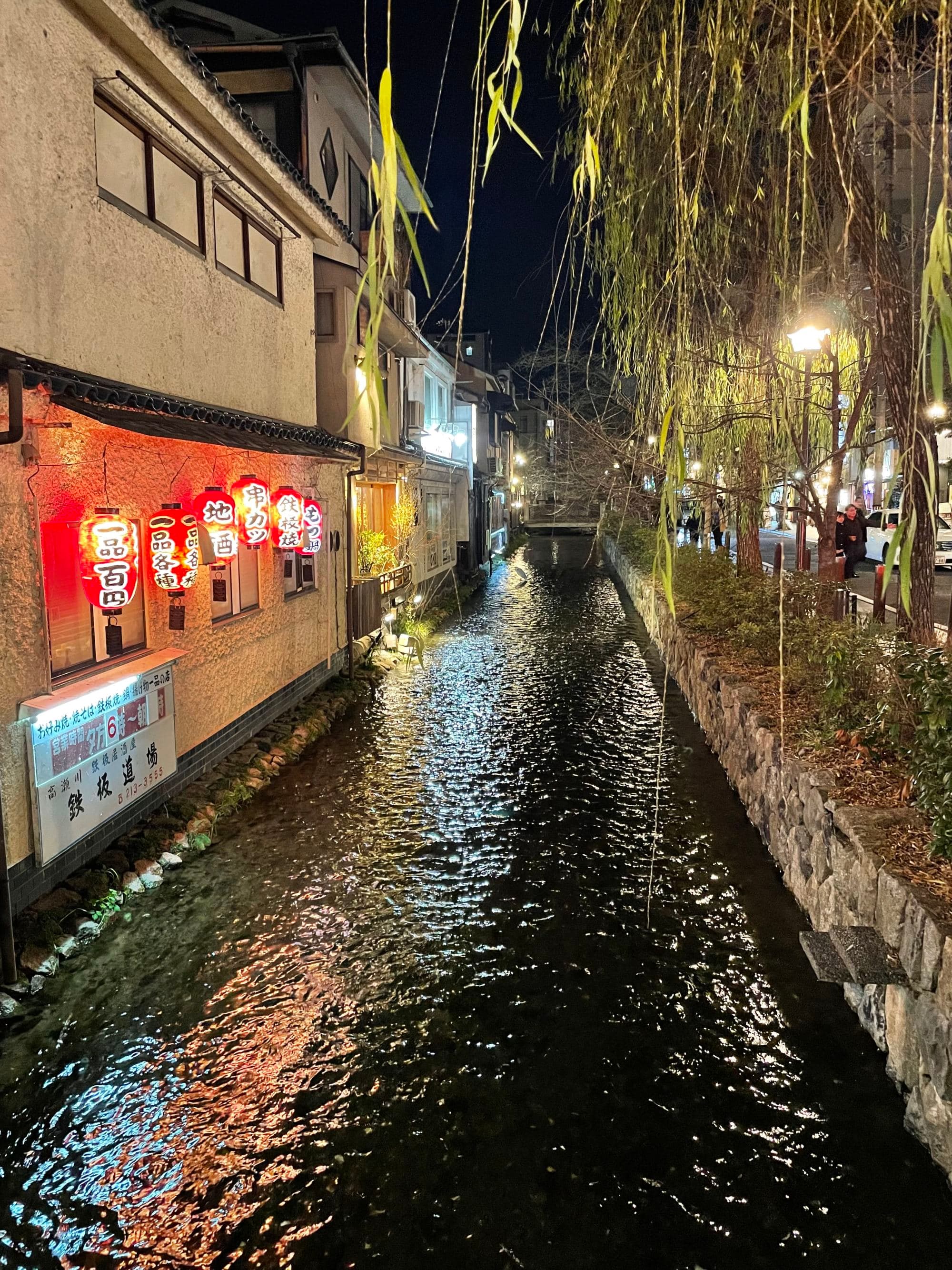 A city canal running through the heart of the city on a cloudy night.