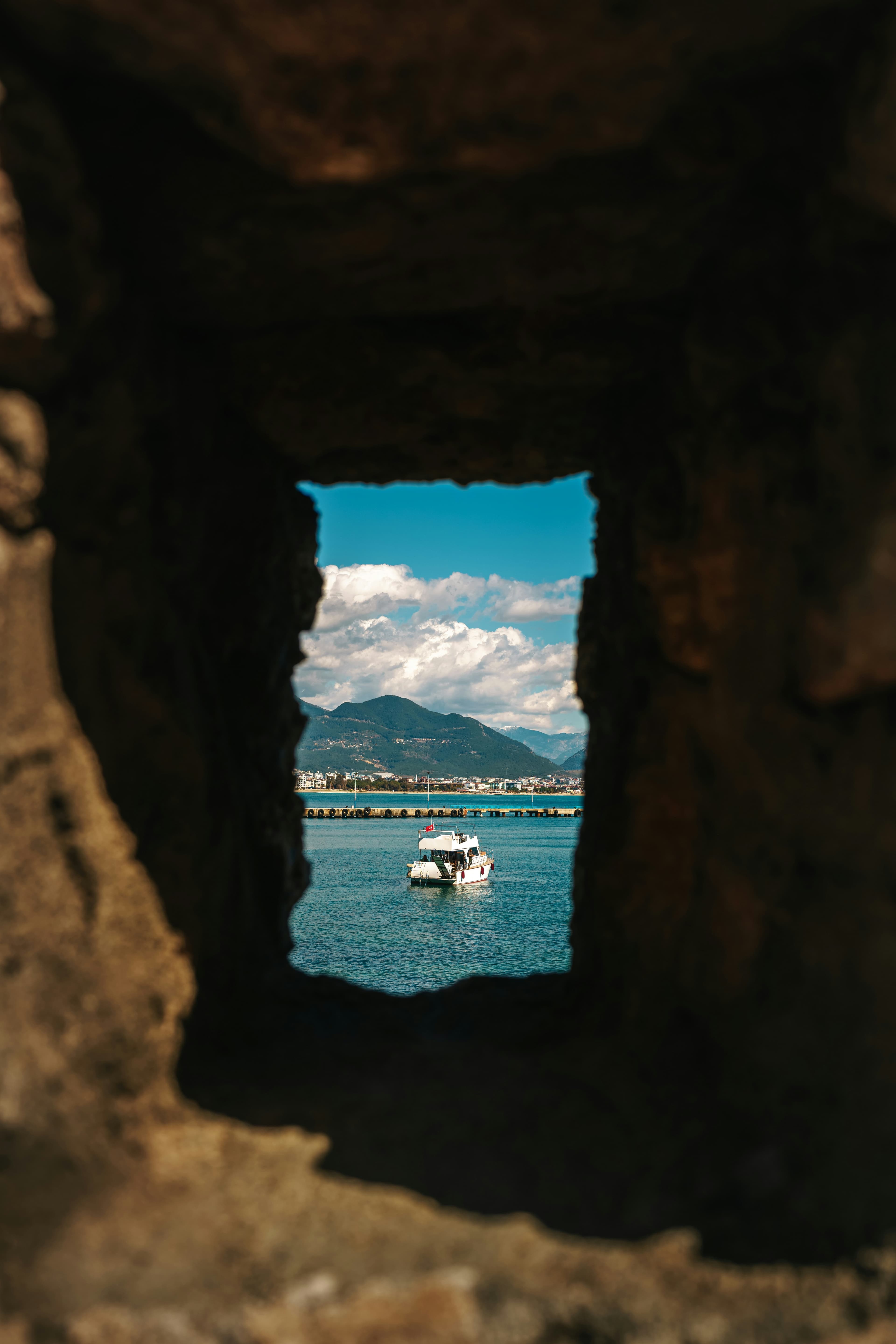 A boat on the water seen through a rock outcropping.