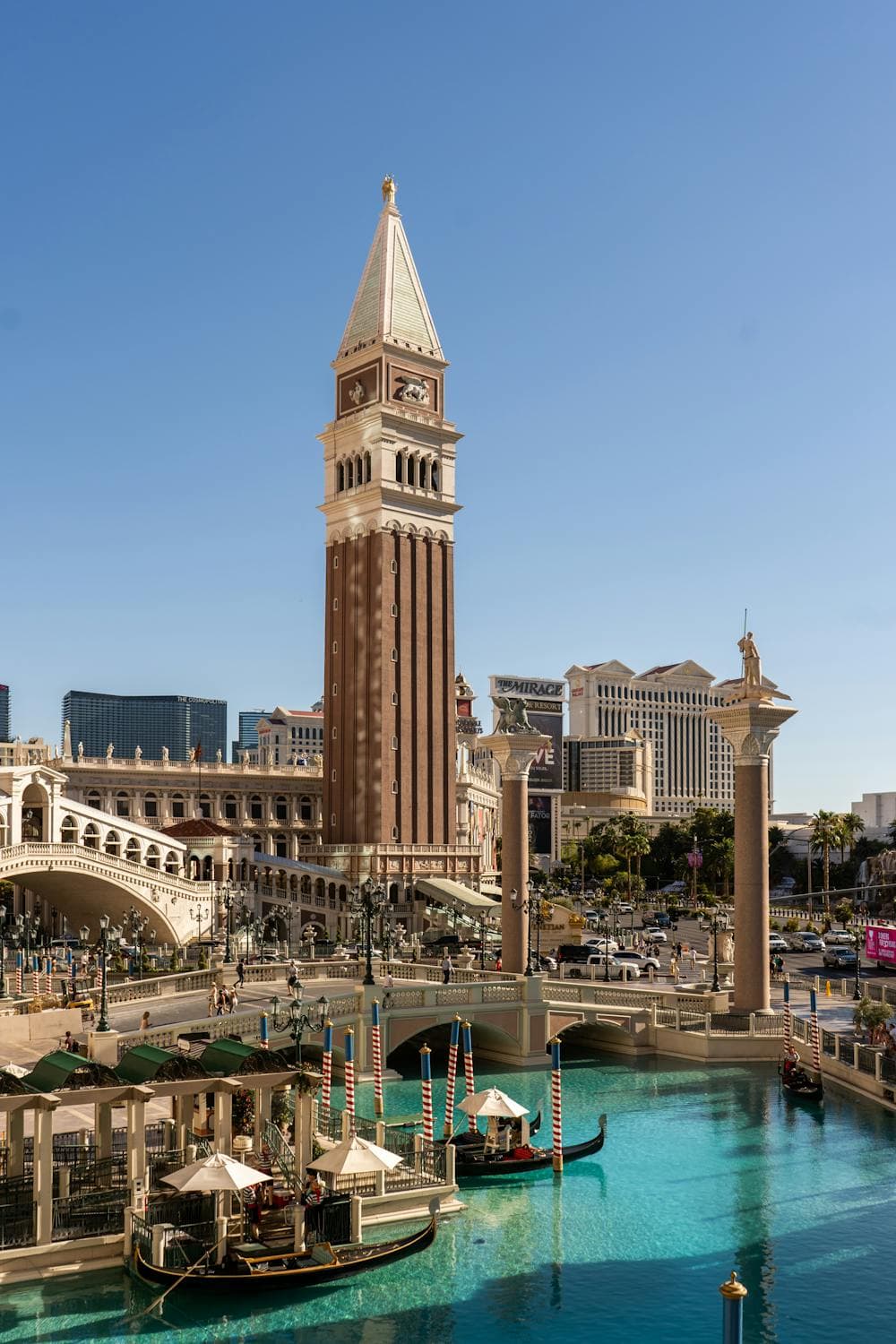 An exterior view of The Venetian Las Vegas with a body of water in front with gondolas.