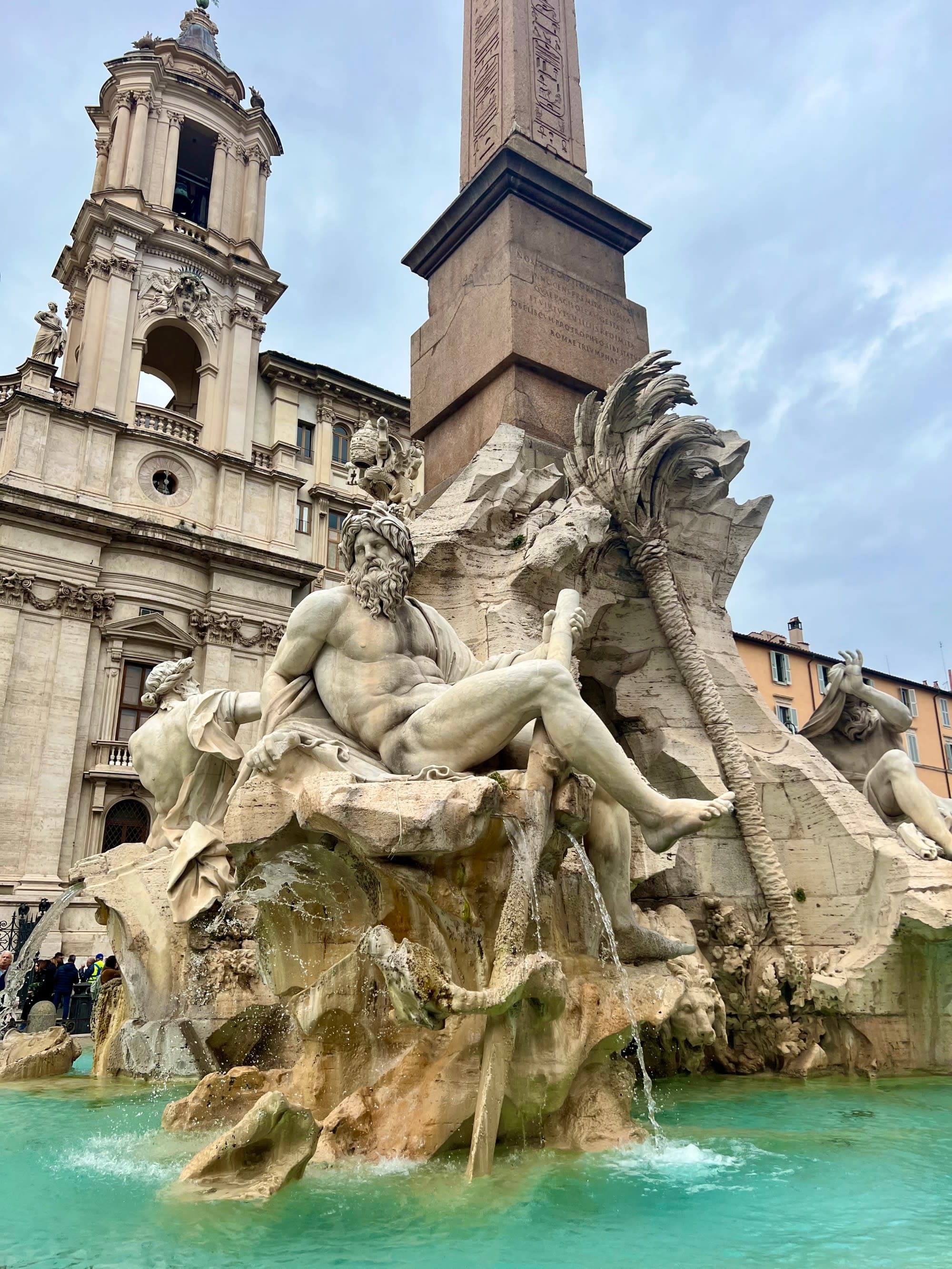 The Fontana dei Quattro Fiumi, a renowned baroque fountain in Rome’s Piazza Navona, adorned with elaborate sculptures and an obelisk.