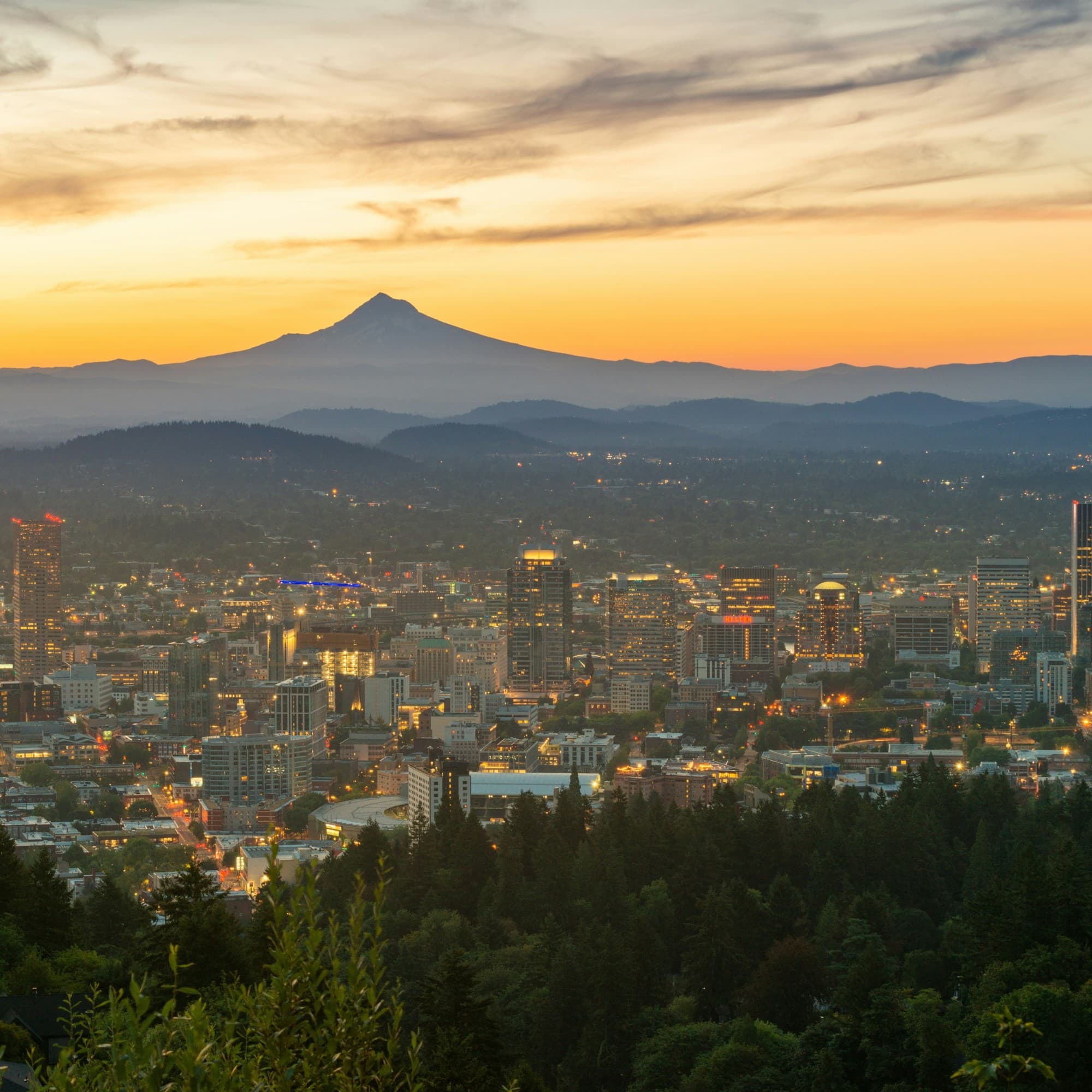 Aerial view of a city during the sunset with a mountain range in the distance