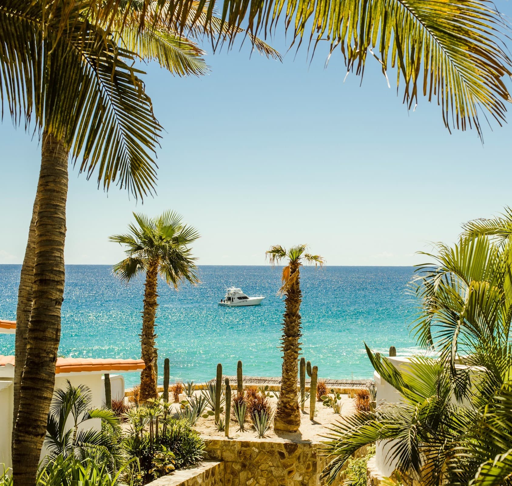 View of the beach and ocean with a small white boat from the resort grounds