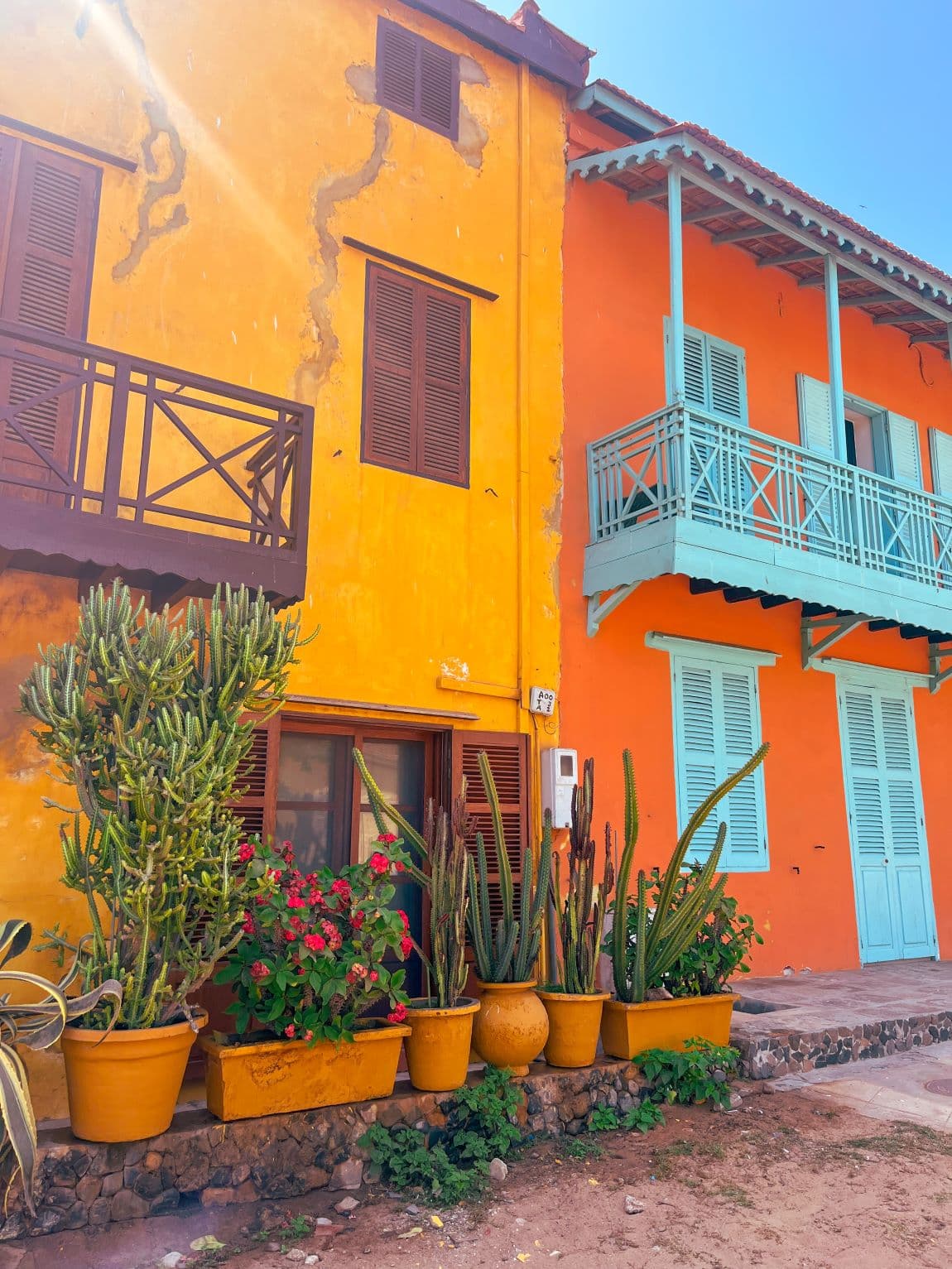 A yellow and an orange building next to each other during the daytime