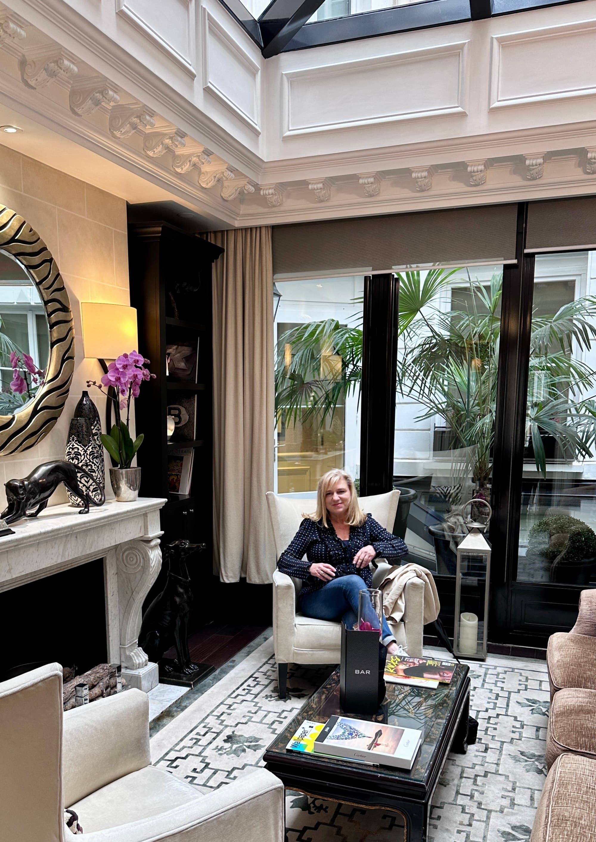 Travel advisor posing in a sitting chair of a luxurious hotel lobby.