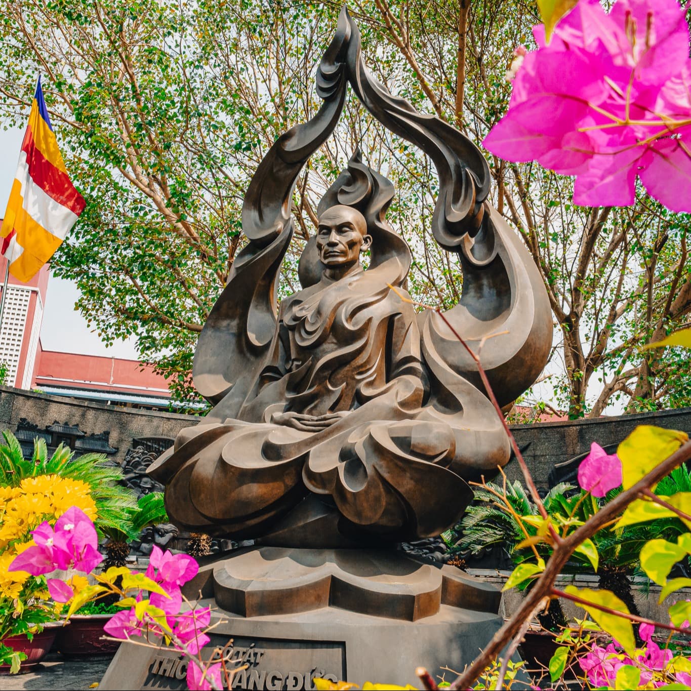 Statue of a Buddha surrounded by foliage.