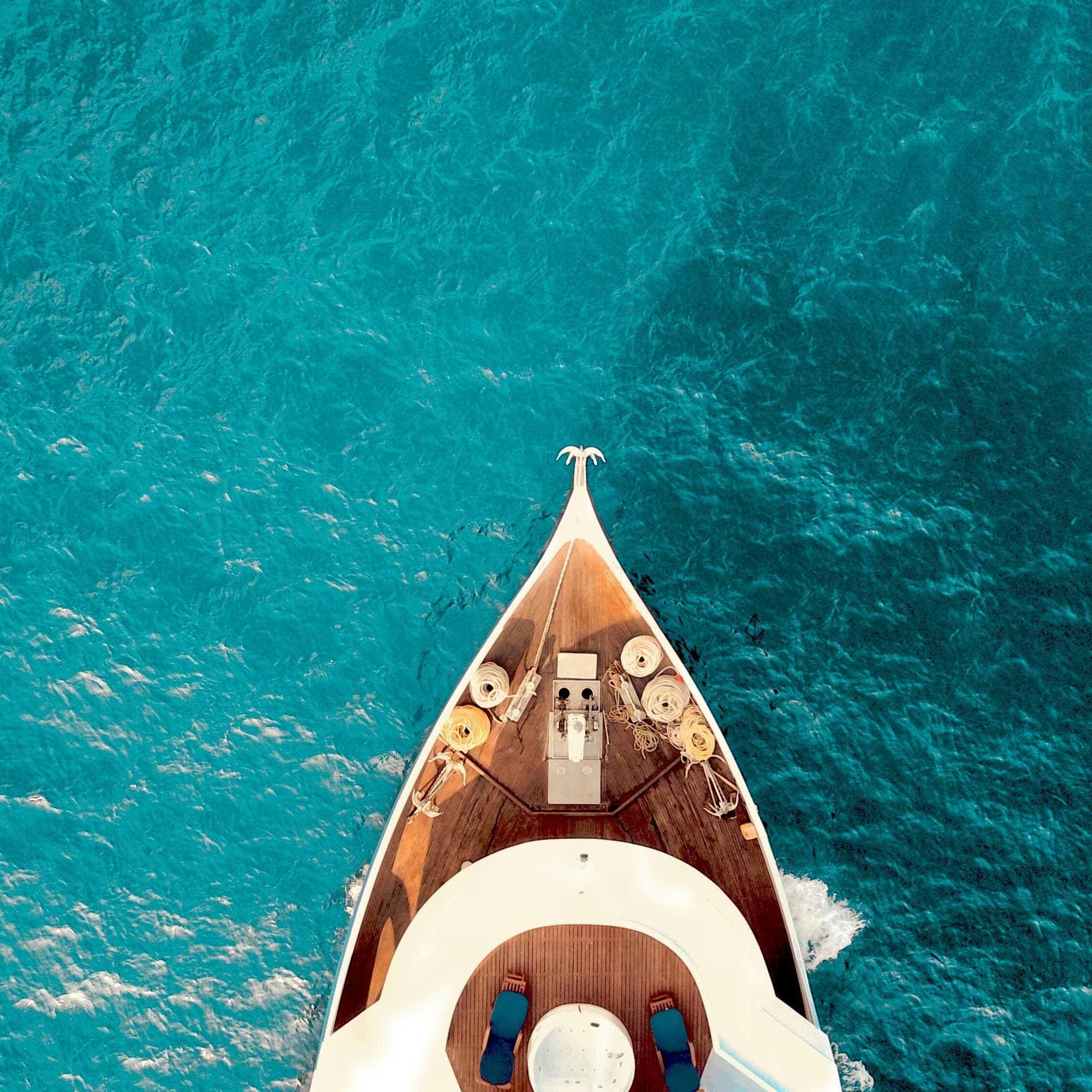 The image captures the essence of adventure with a boat’s bow slicing through the serene blue waters.