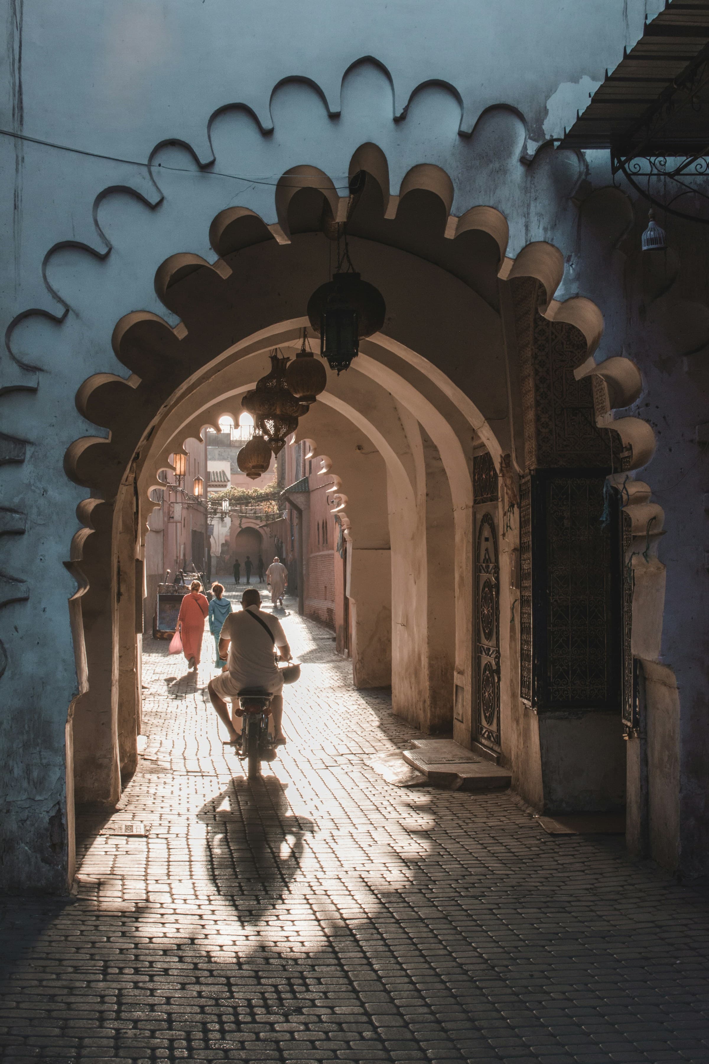 Ornate tunnel in a Marrakesh street with a man on a bike