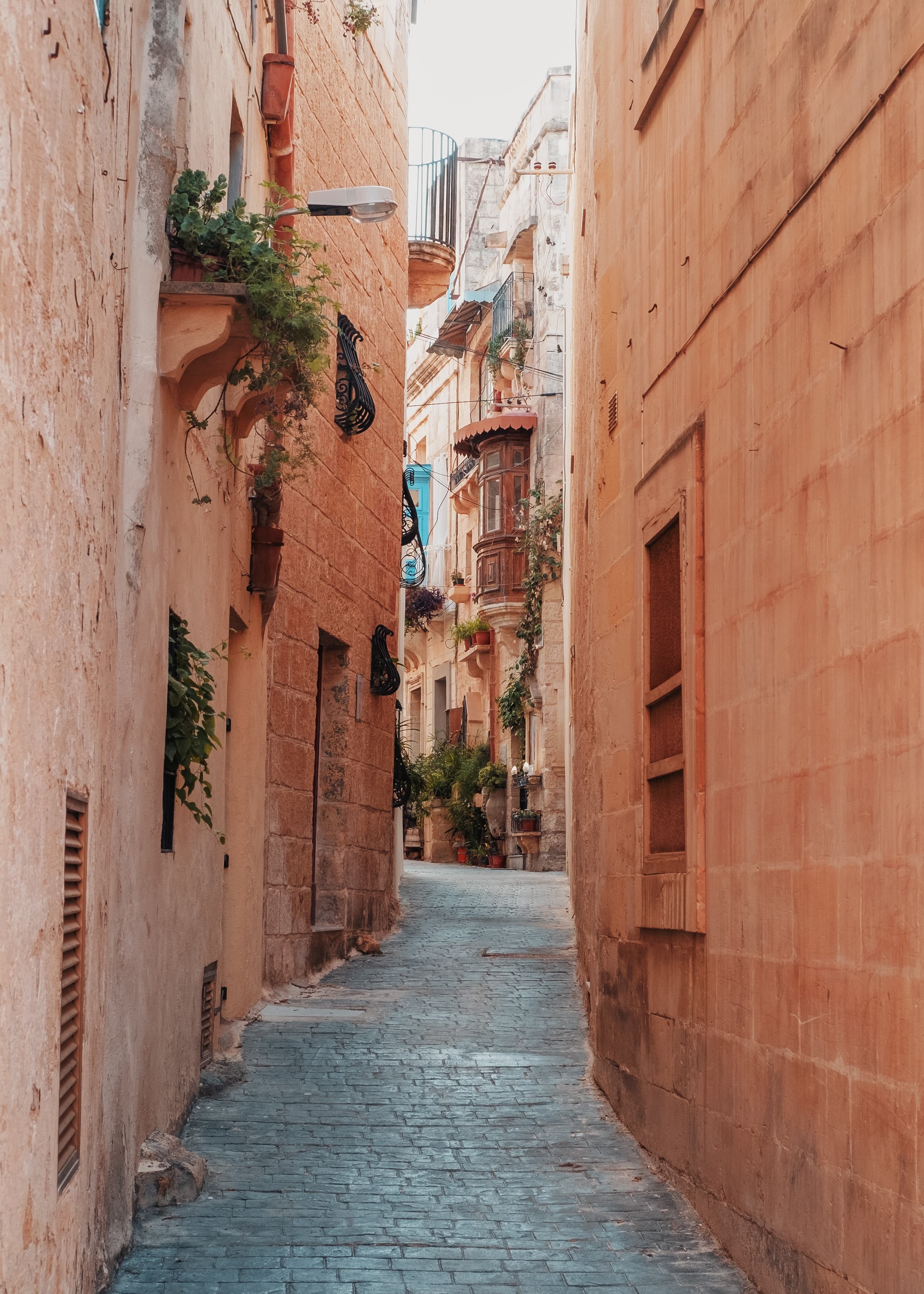 Cobblestone street lined with beige buildings during daytime