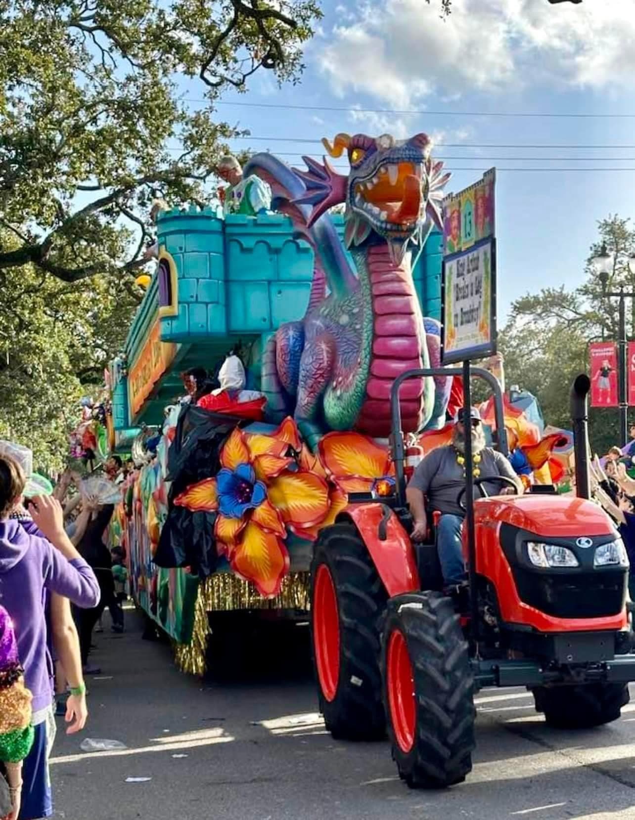 A parade float with a depiction of a dragon and castle