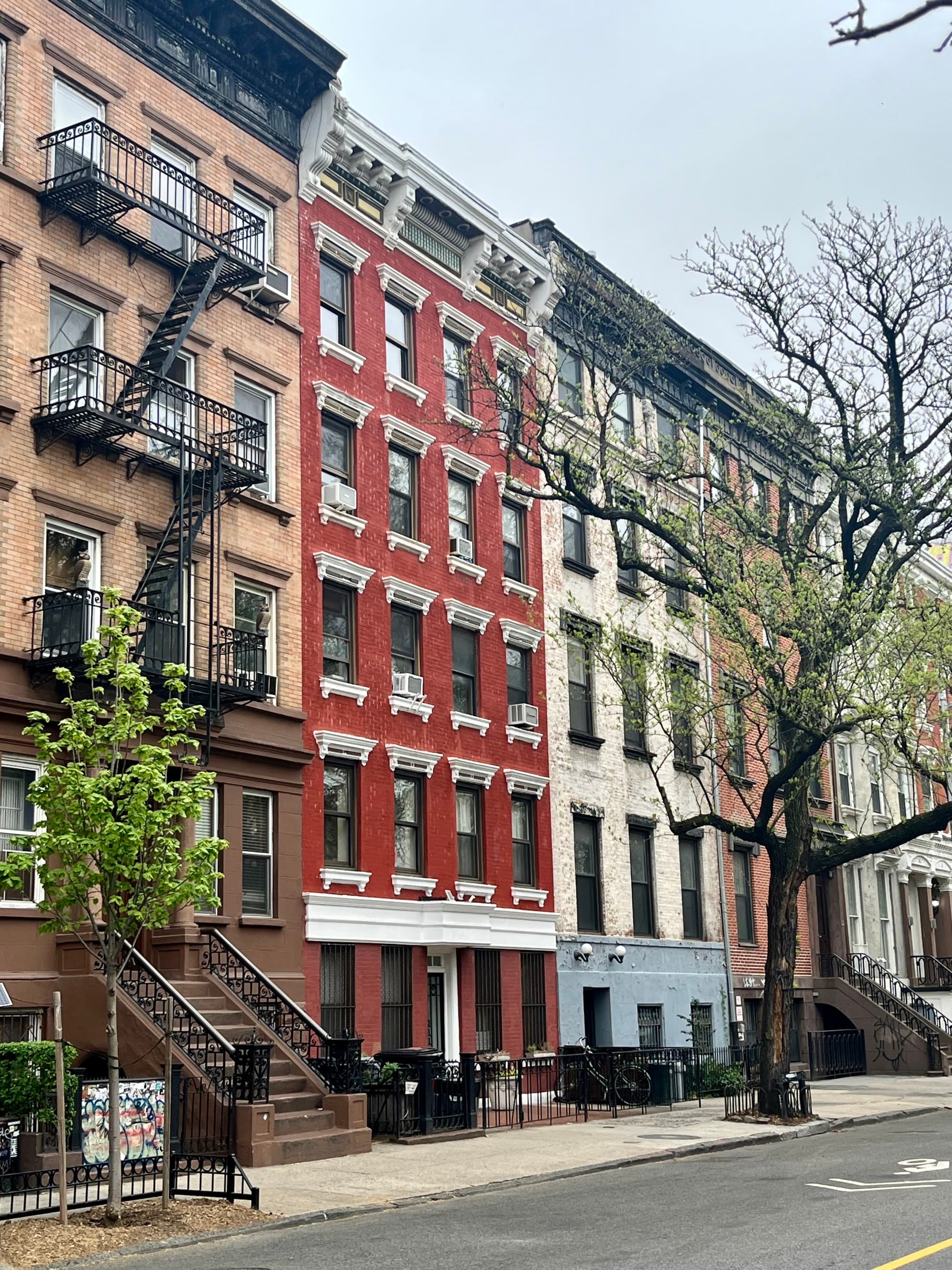 Red, beige and brick buildings in a row.