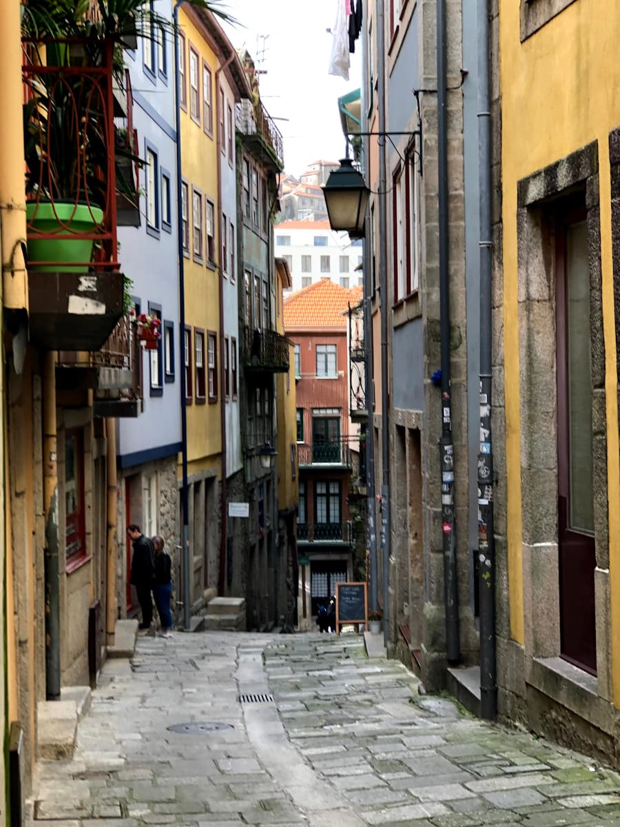 A view of a narrow alleyway with residential buildings in Porto, Portugal.