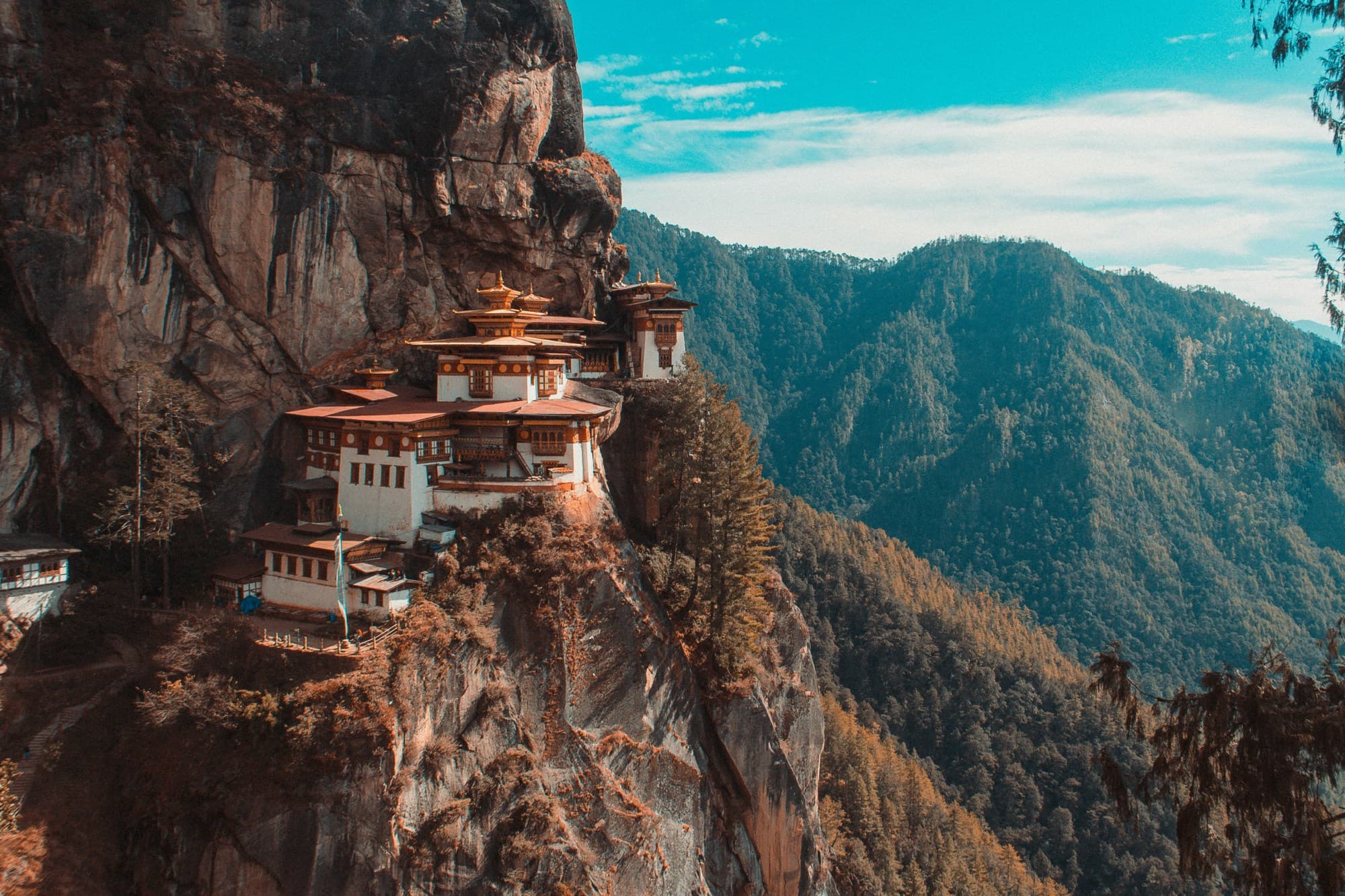 A scenic view of Tiget's Nest Monastery nestled on the edge of a cliff in Bhutan.