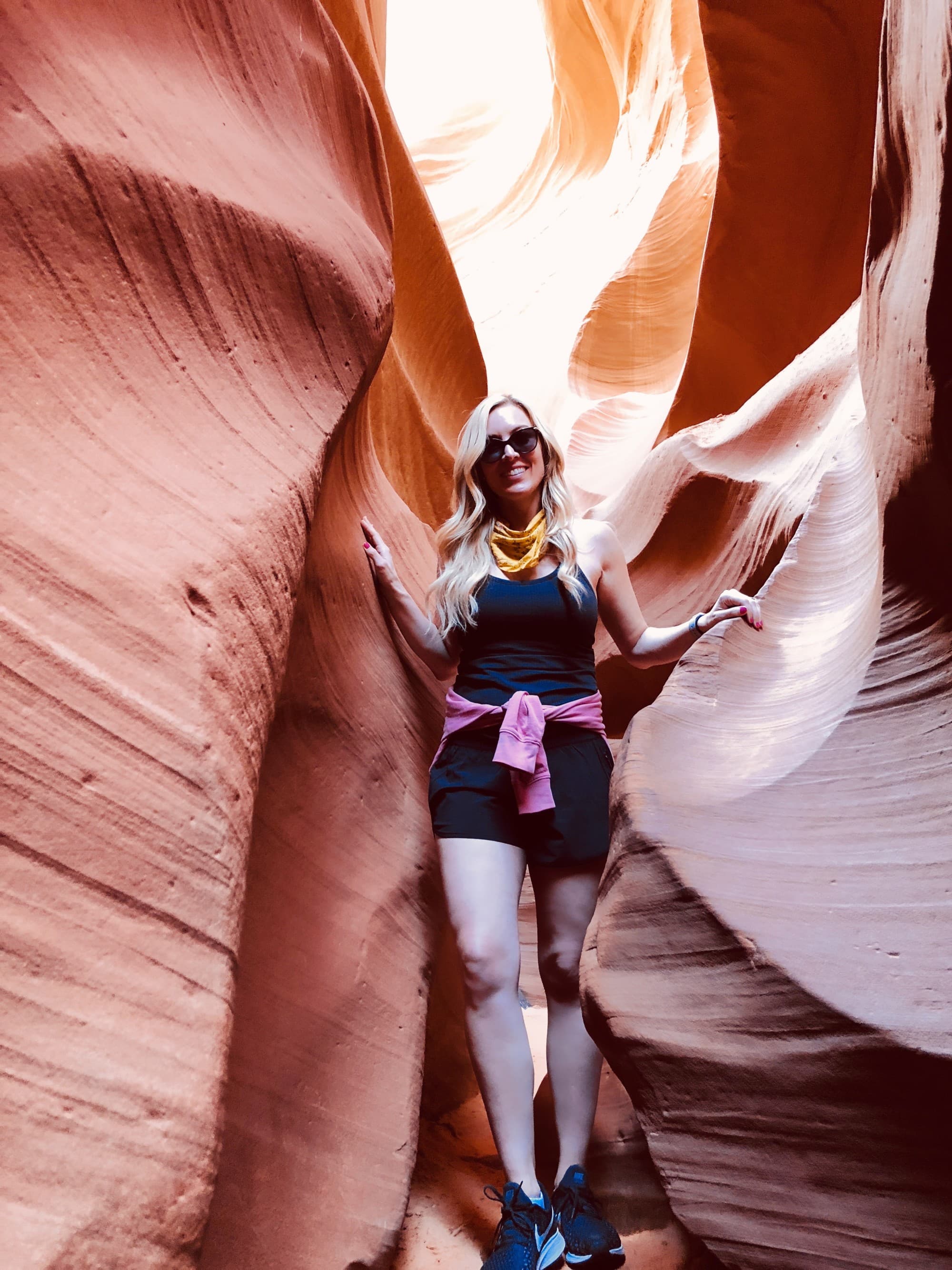 Woman standing between two rocky hills.