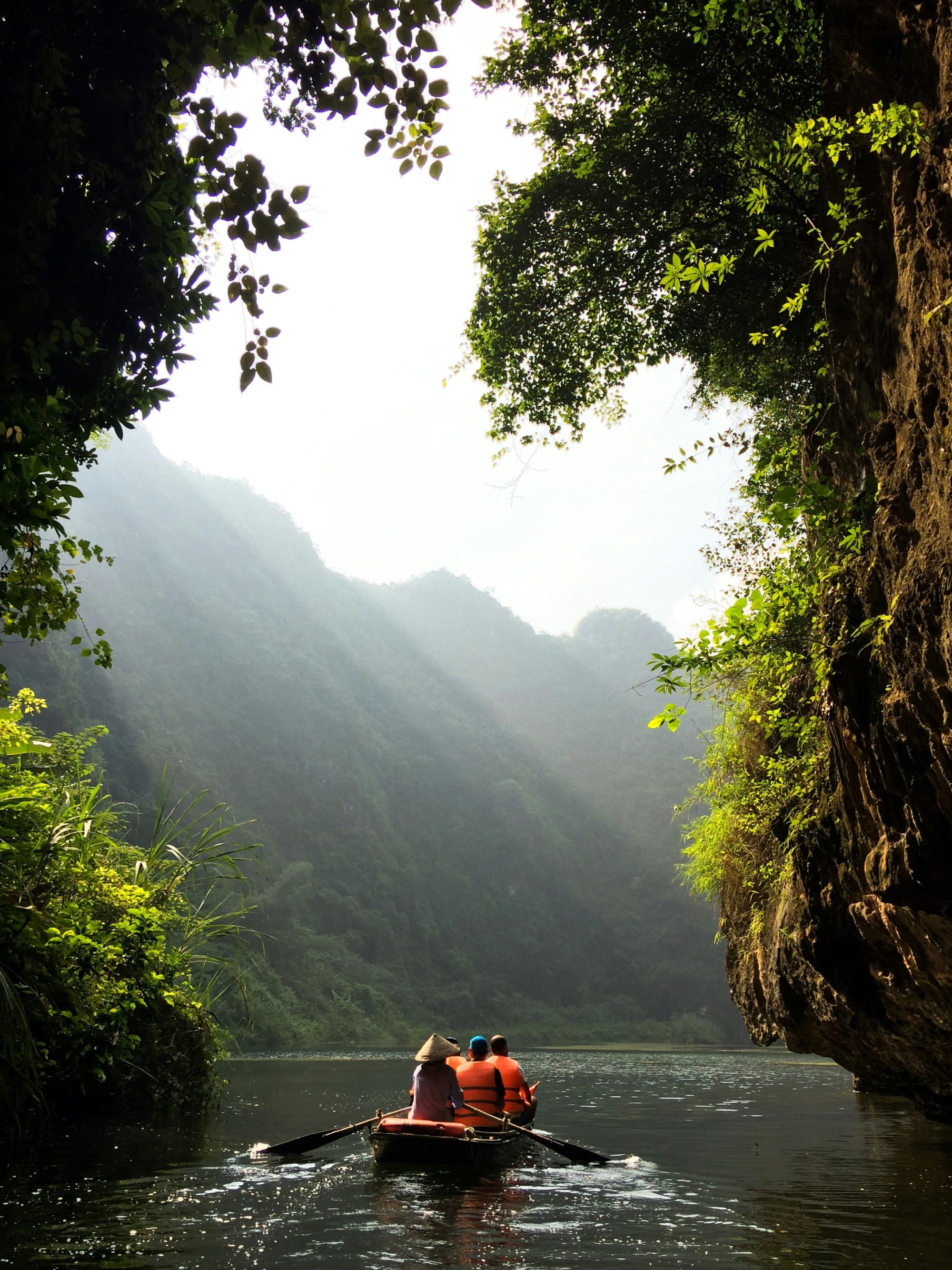 A picture of a group of people rowing a boat on water during the daytime.