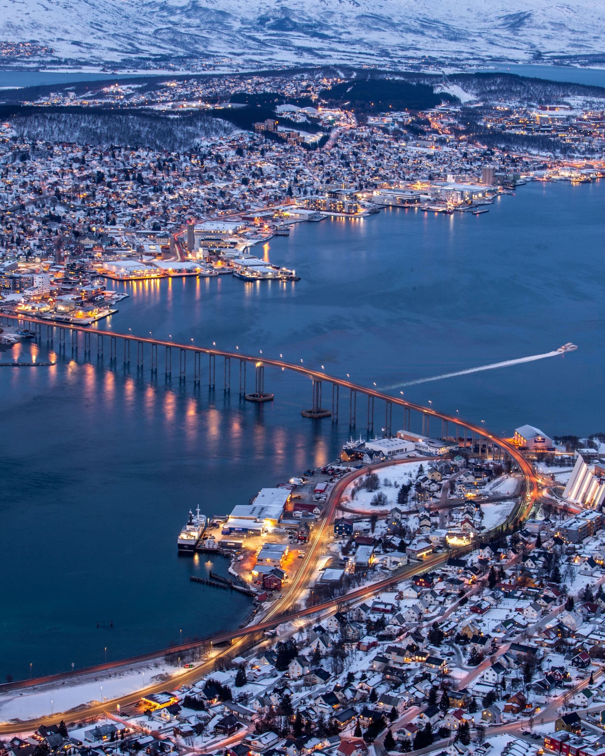 snowy city with lights and a bridge