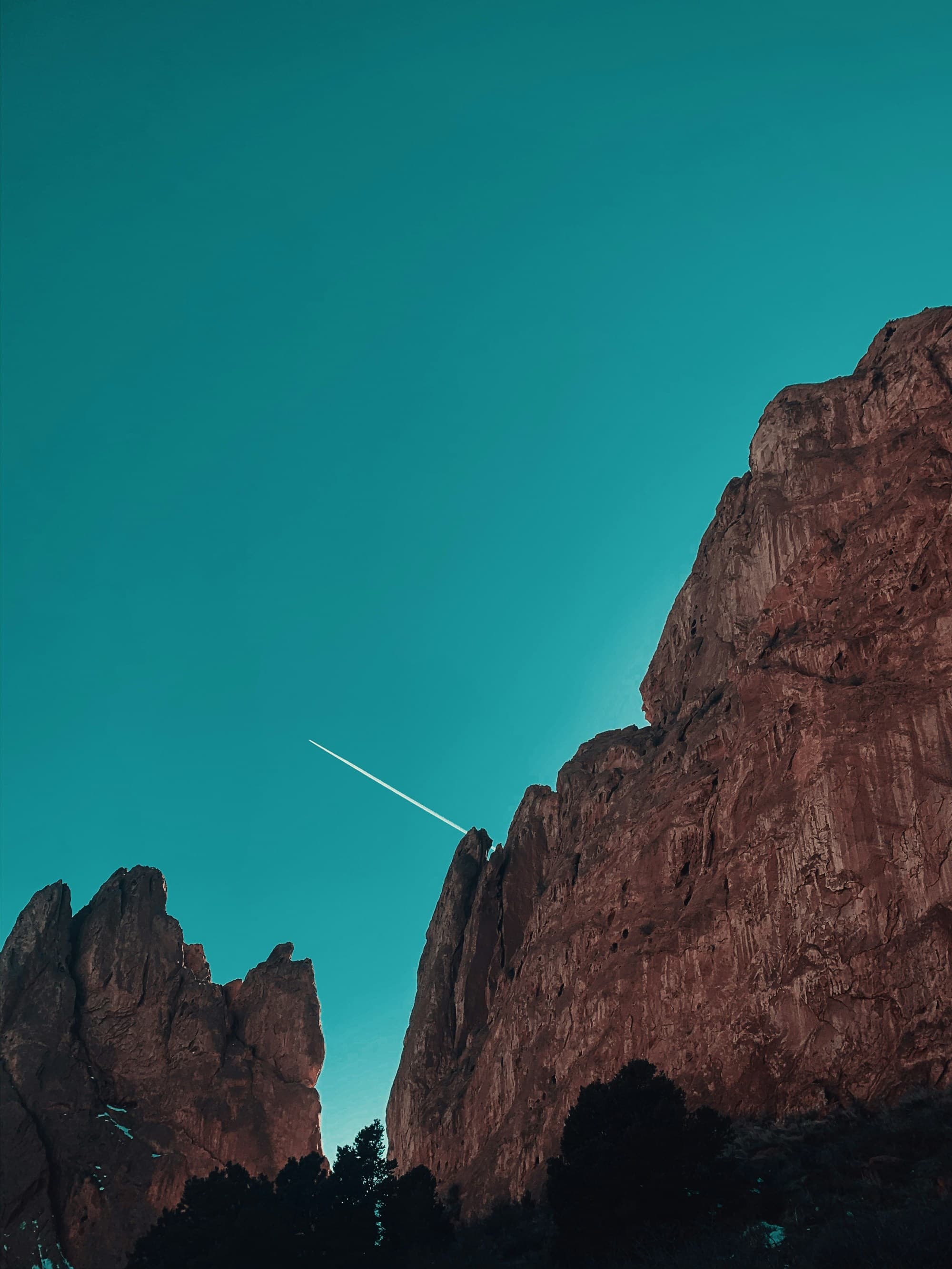 A picture of a brown rocky mountain under the blue sky during the daytime.