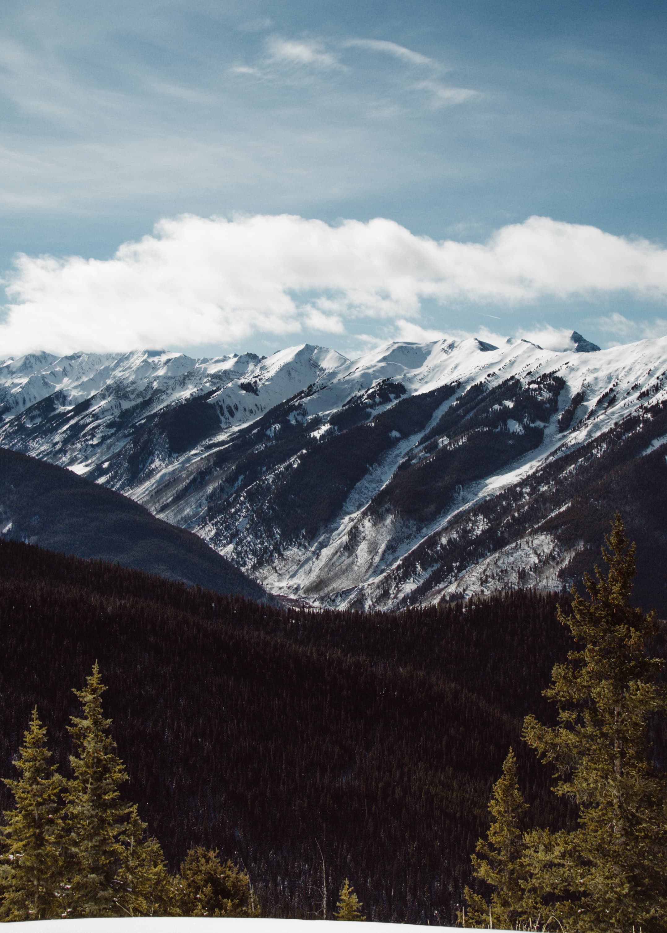 snowy mountains with cloudy skies during daytime