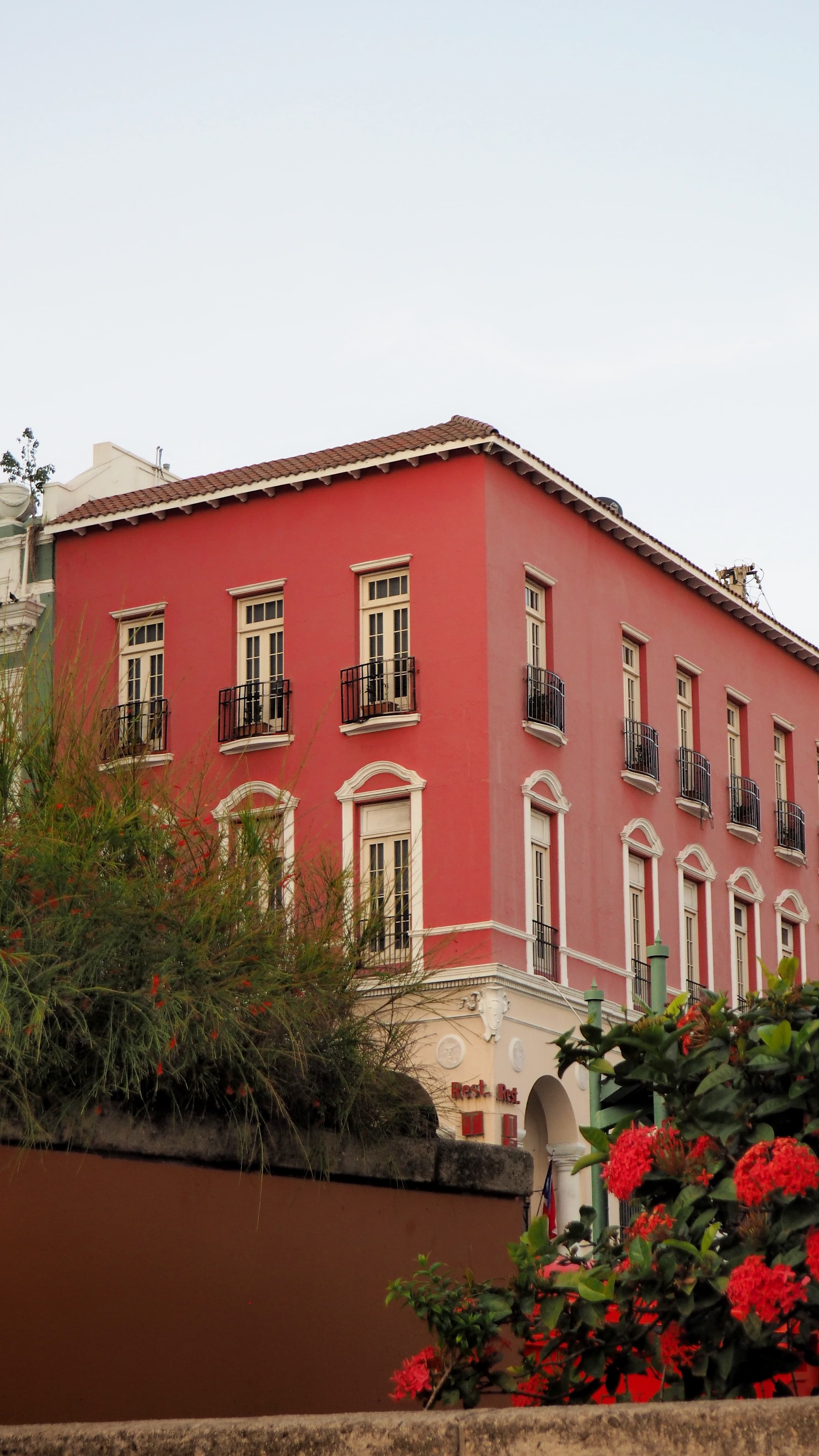 A red house flanked by tropical fauna and flowers in Puerto Rico.