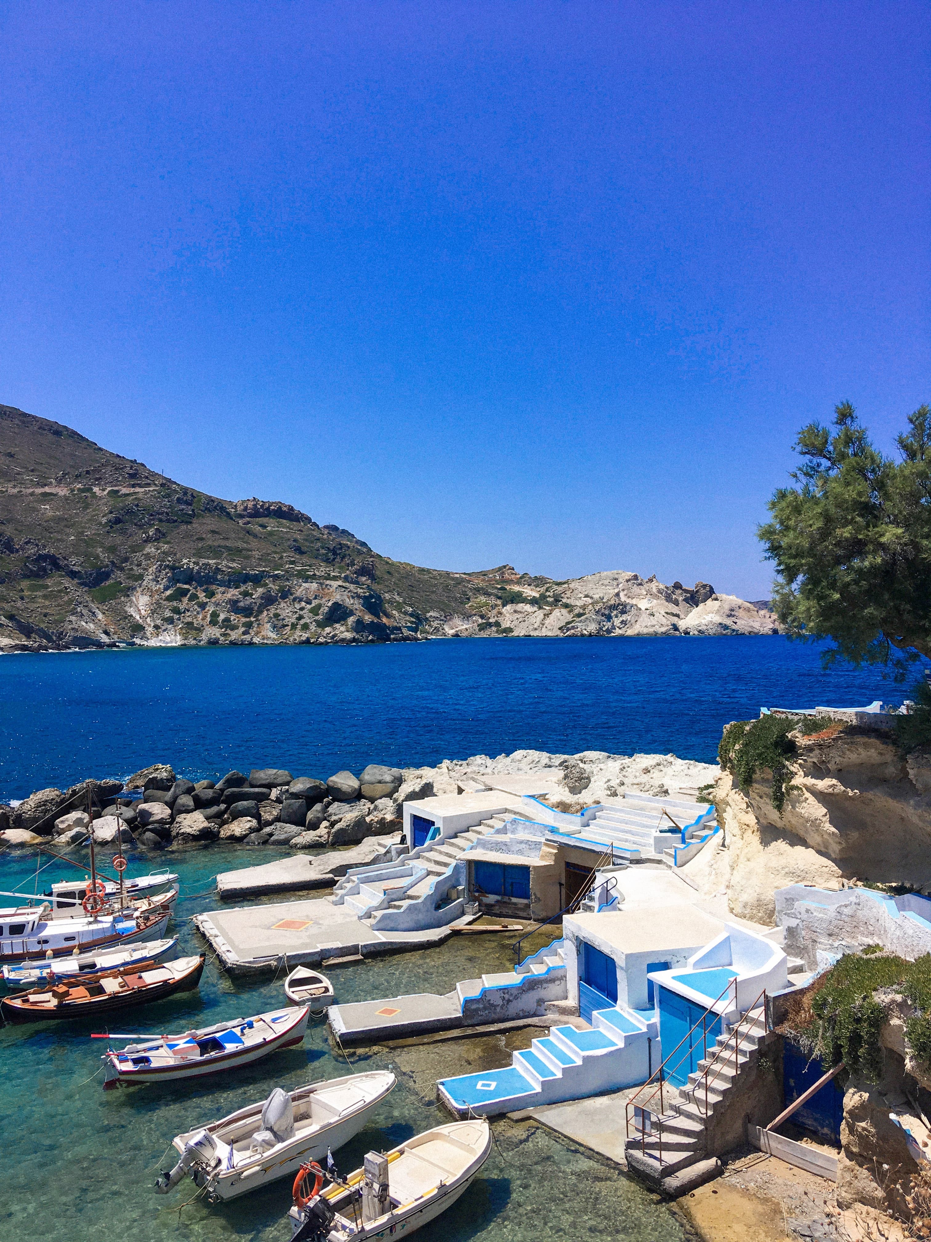 Boats next to small homes and body of water during daytime