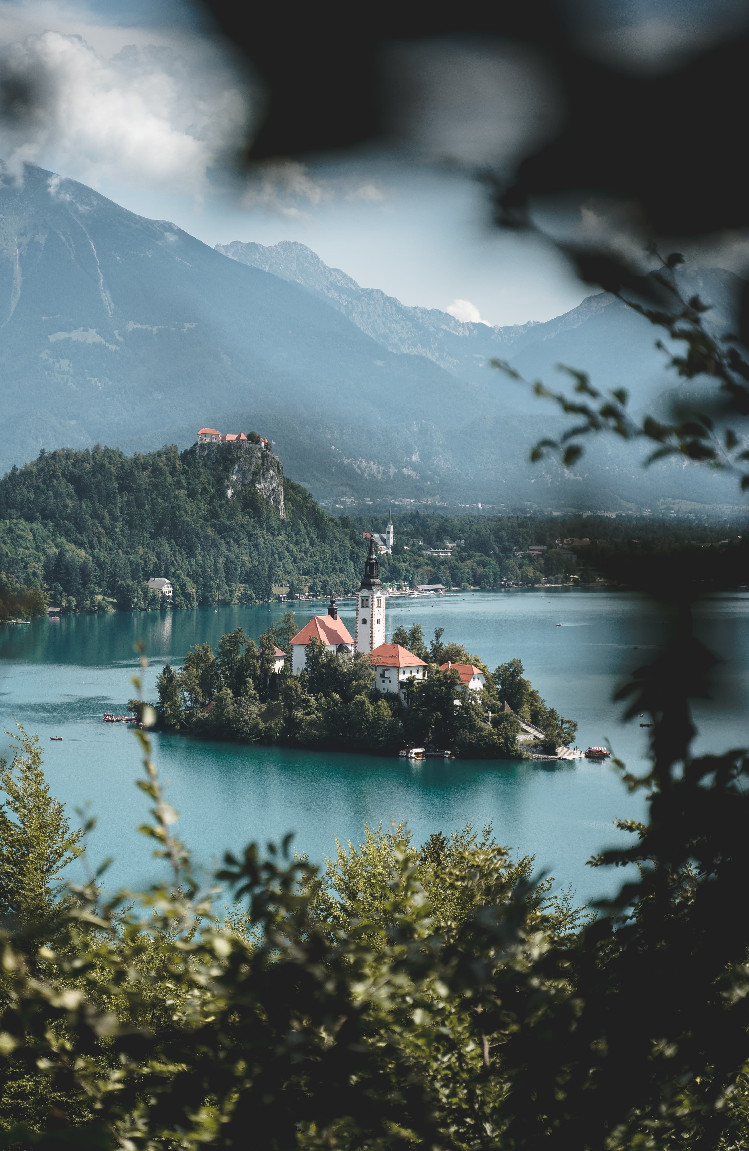 Island with red-brick houses and a church in the middle of Lake Bled in Slovenia.