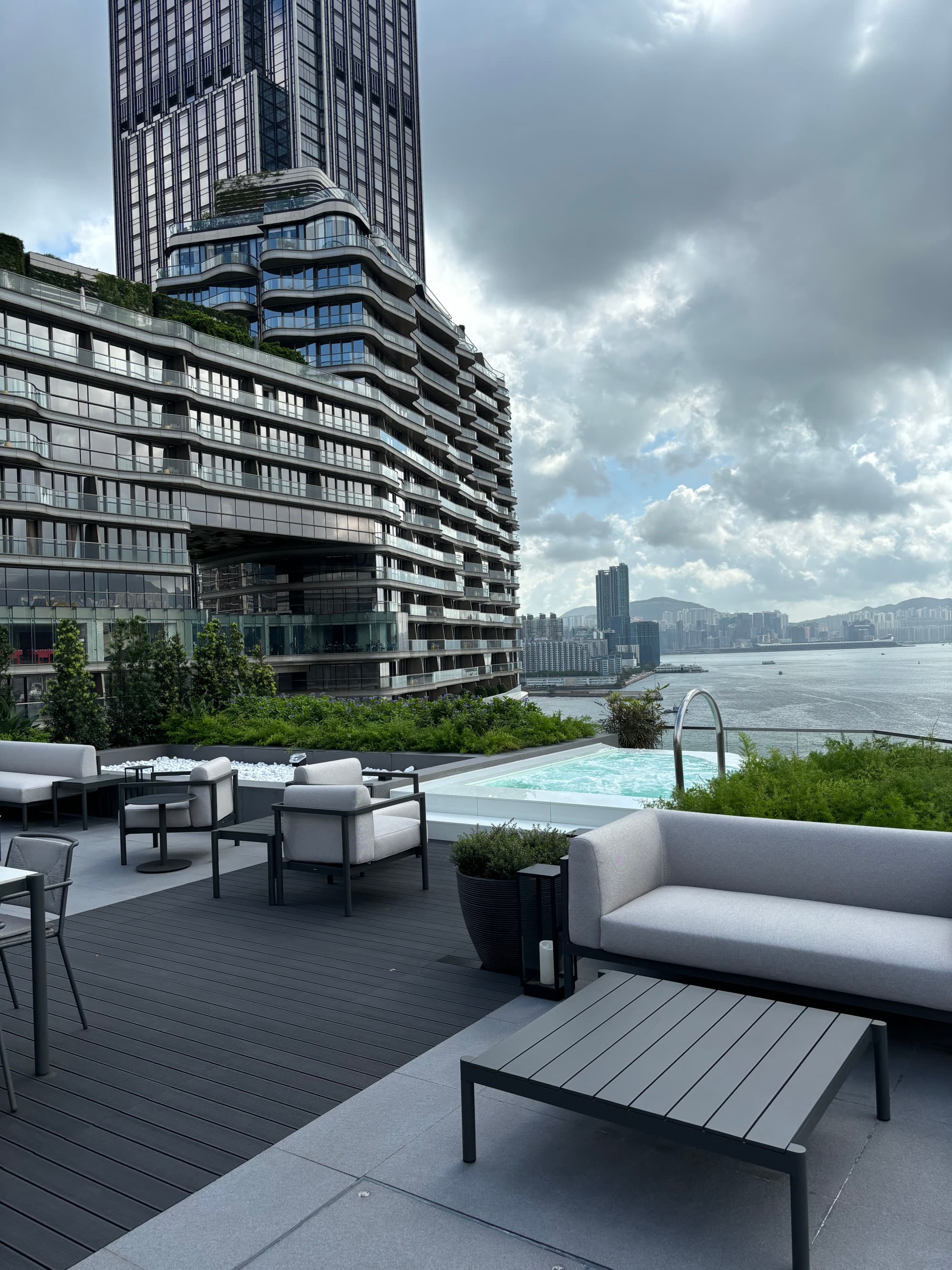 An outside patio with seating and view of a tall city building during a cloudy day