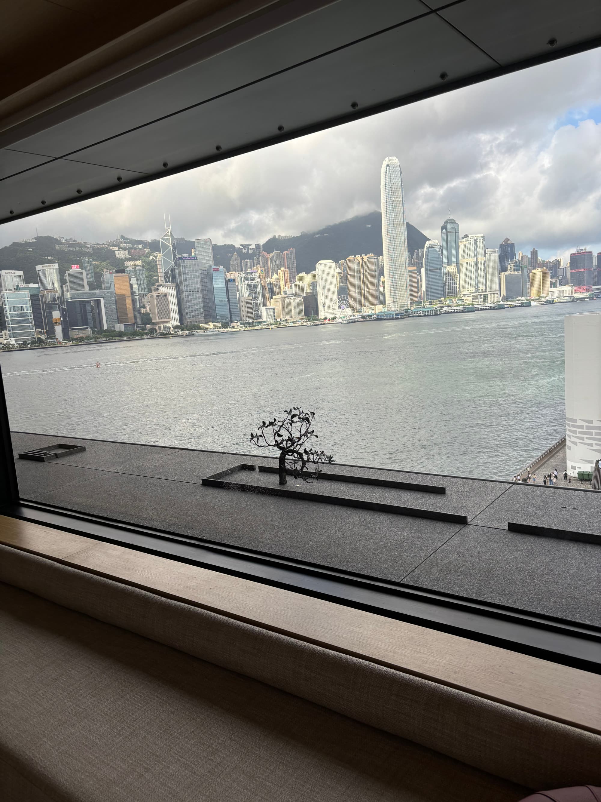 View through a window of city buildings next to a body of water