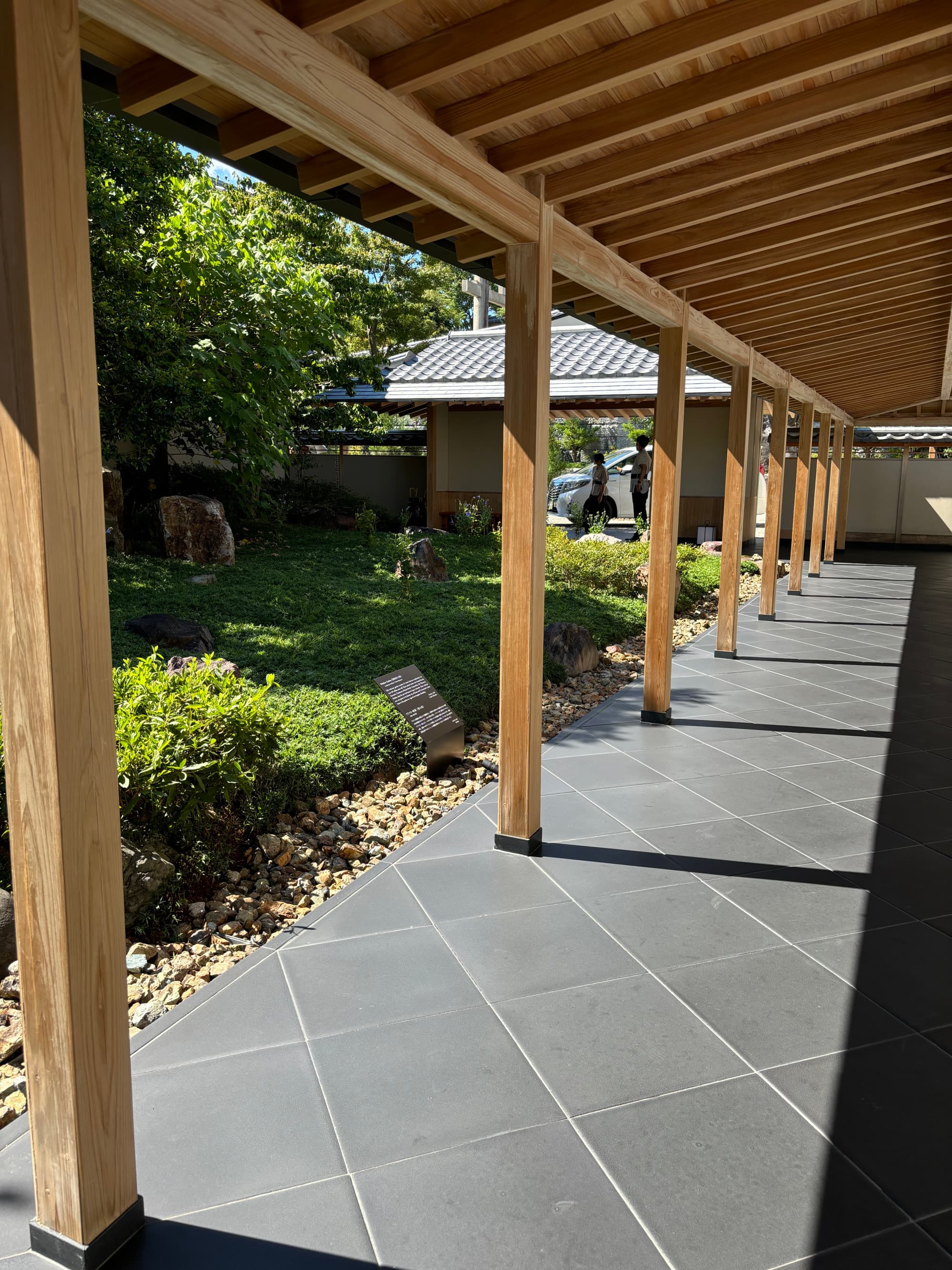 An open-air balcony area in front of a garden