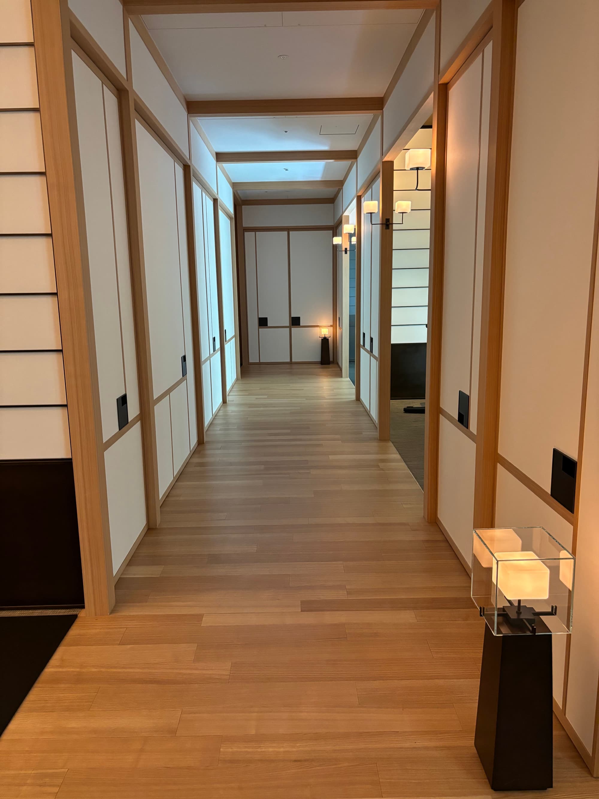 A hotel hallway with white walls and doors on either side