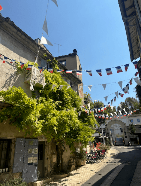 A street between buildings with flags above