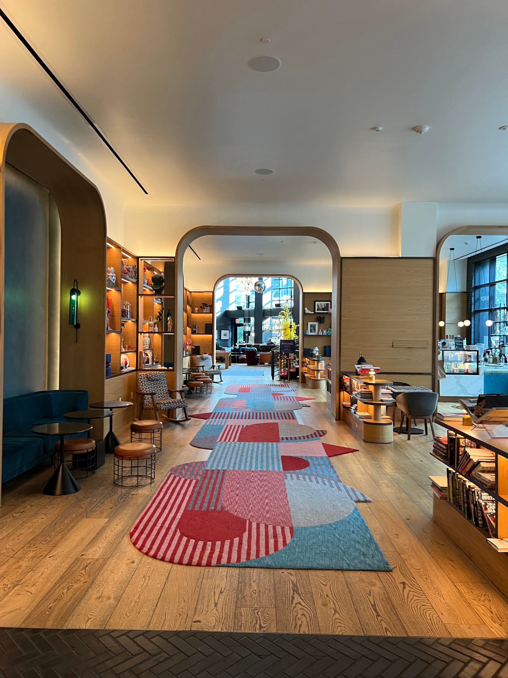 A hotel lobby with an abstract red and blue rug running down the hallway