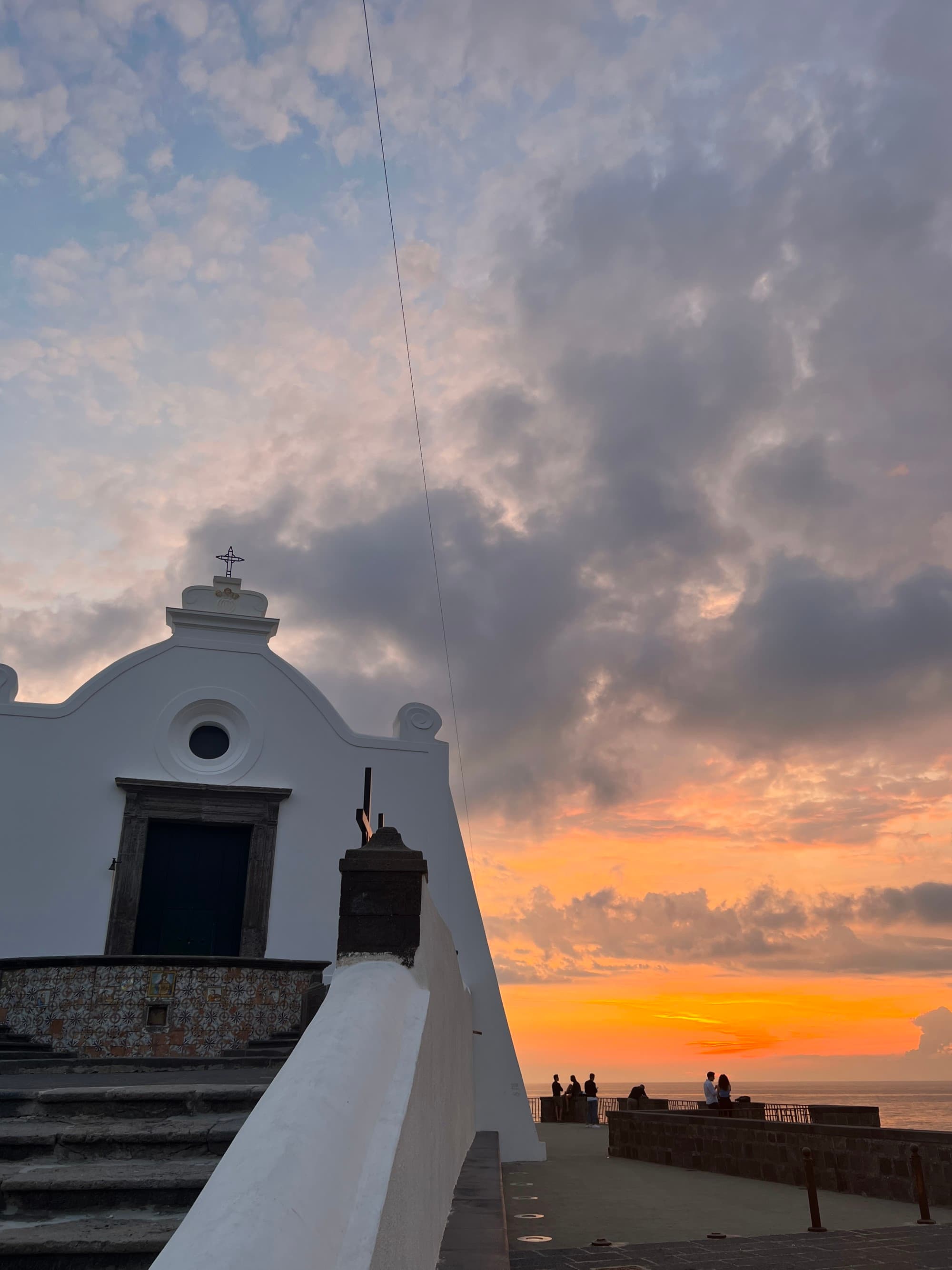 A white building in front of an orange sunset view