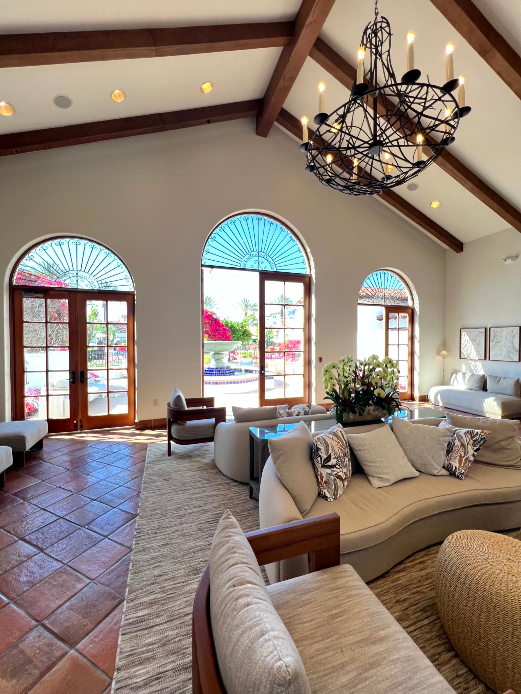 A large living room area with couches and glass doors looking out at a pool.