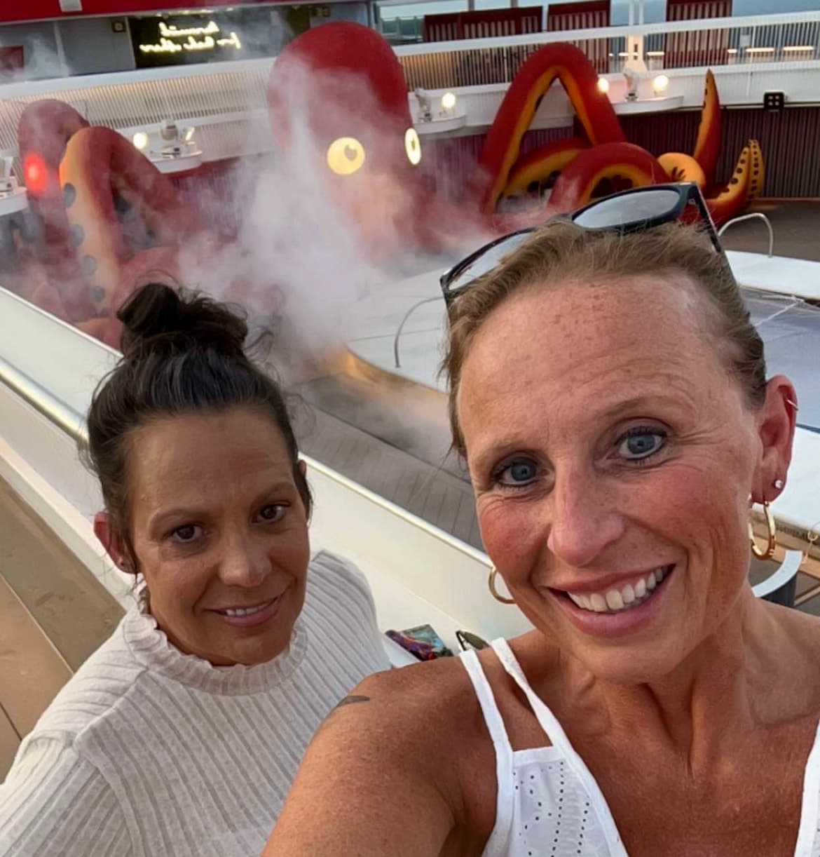 Selfie of two women in front of a pool.