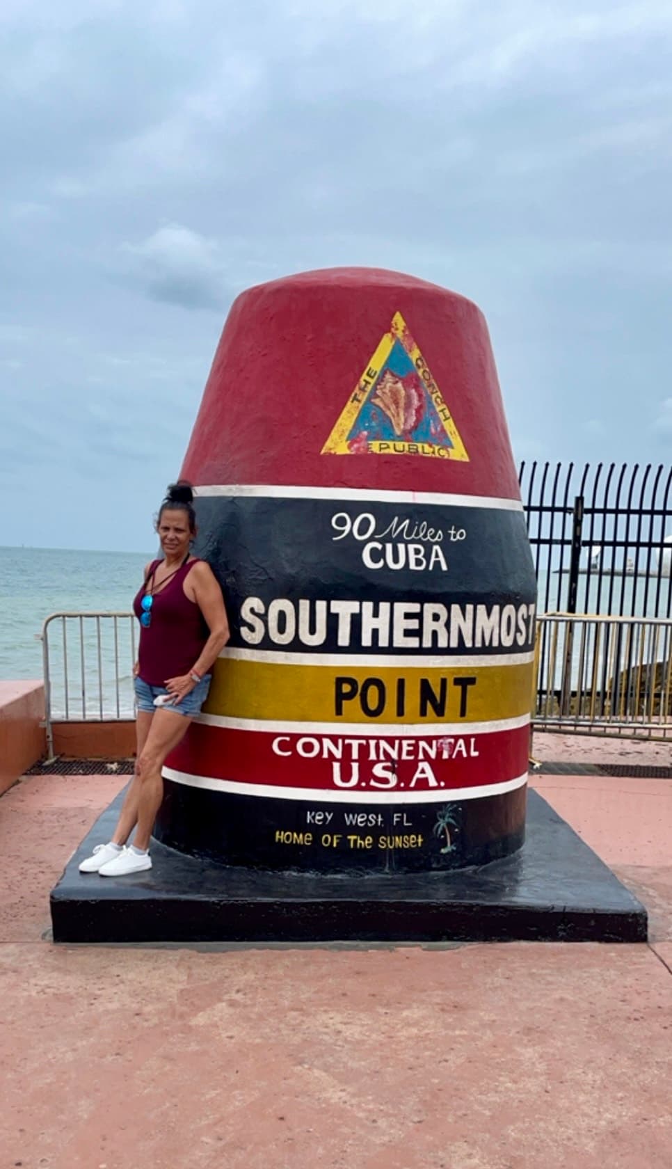 Advisor poses in front of a "Southernmost Point" statue.