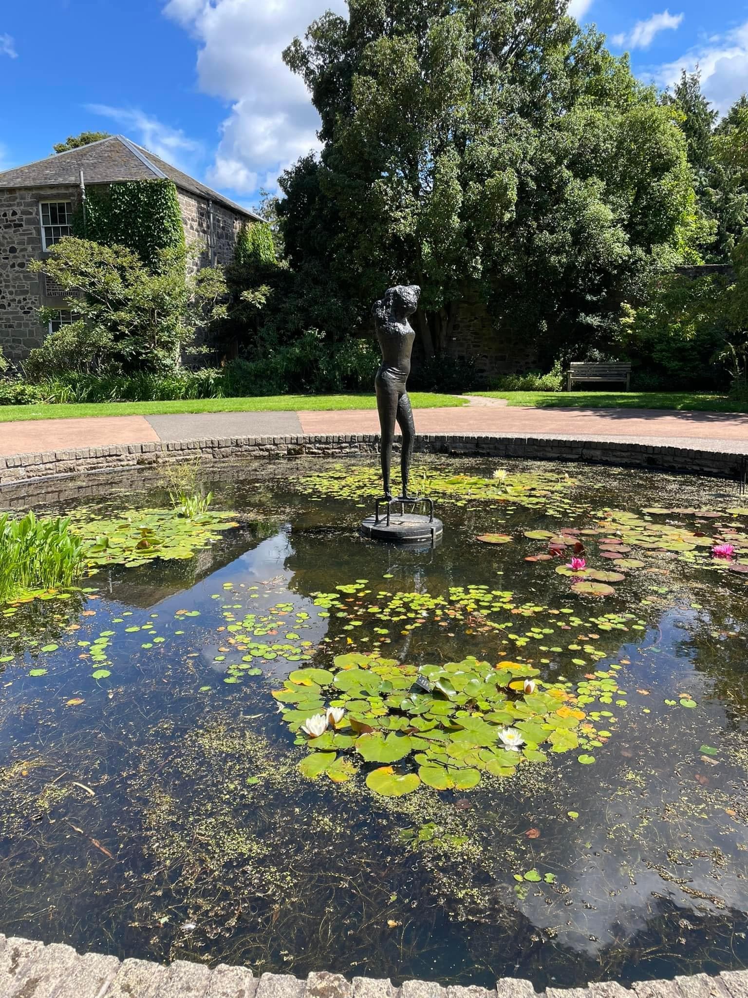 Fountain with a Statue and lily pads floating inside in Edinburgh