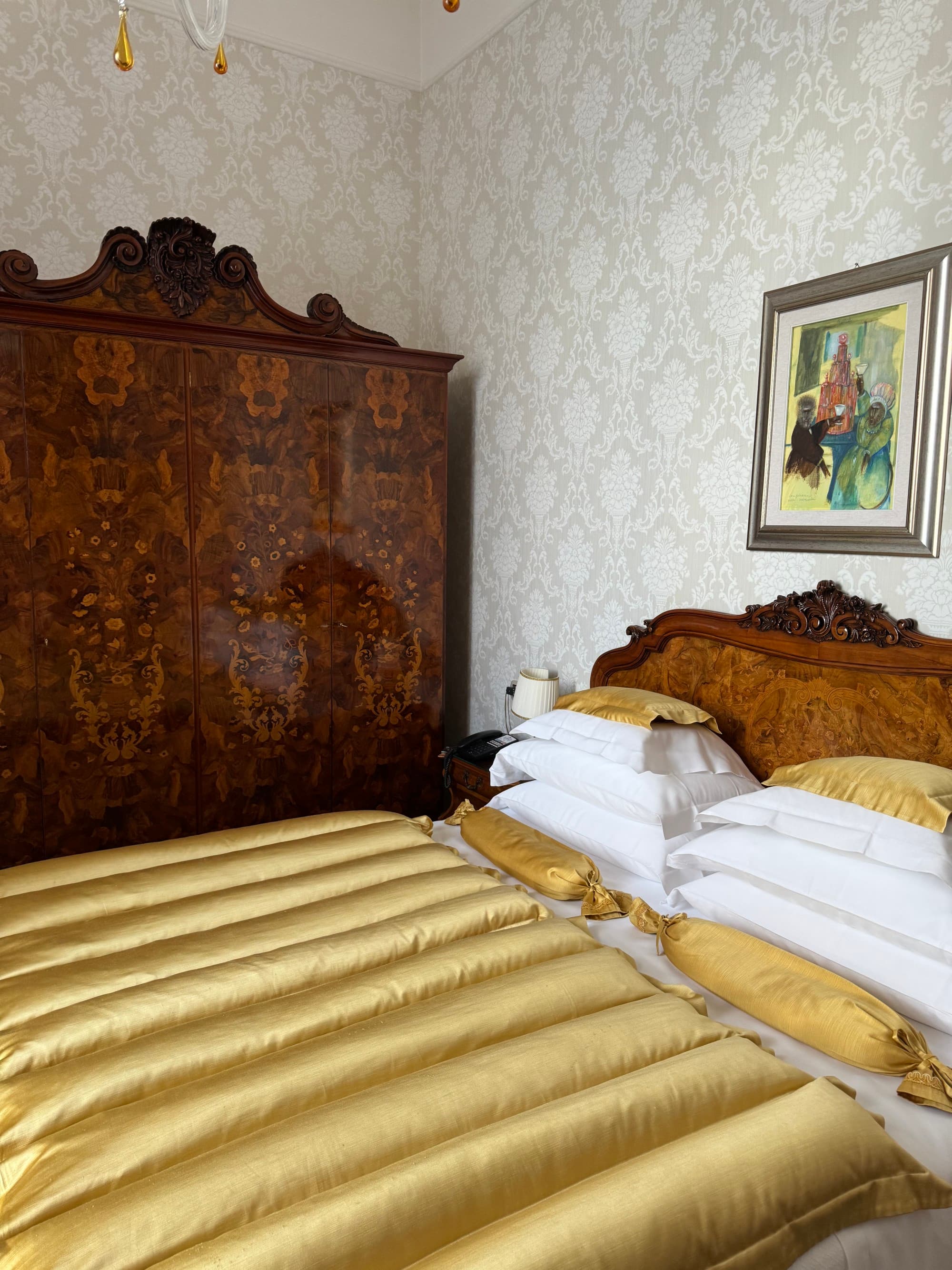 Hotel room bed next to a large dresser.