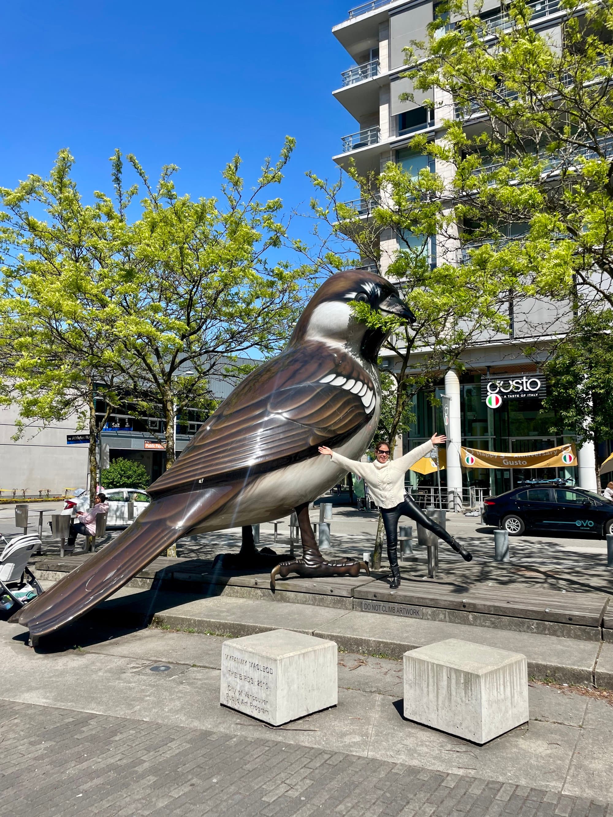 Travel advisor posing in front of a bird statue