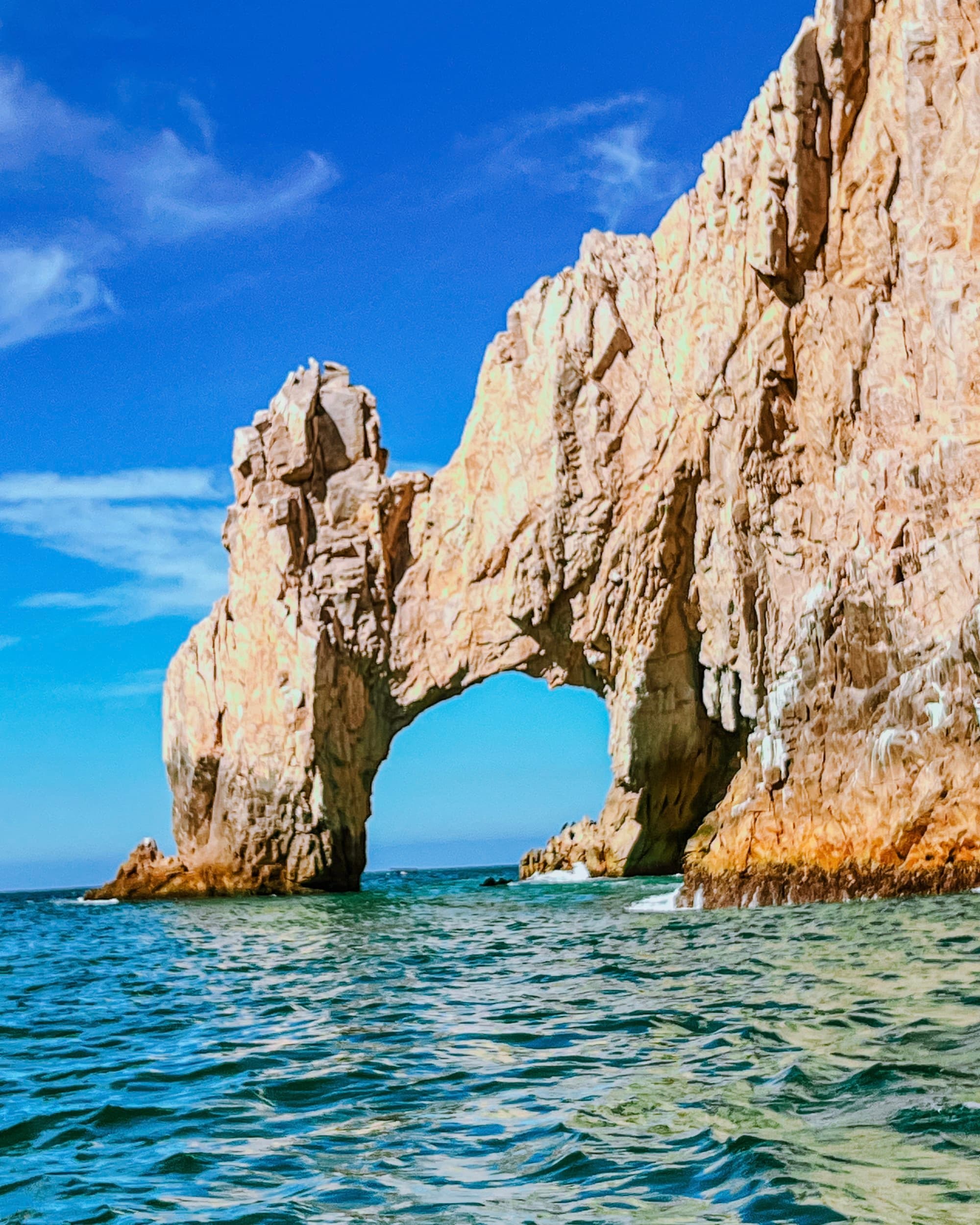 An arch rock formation over the ocean.