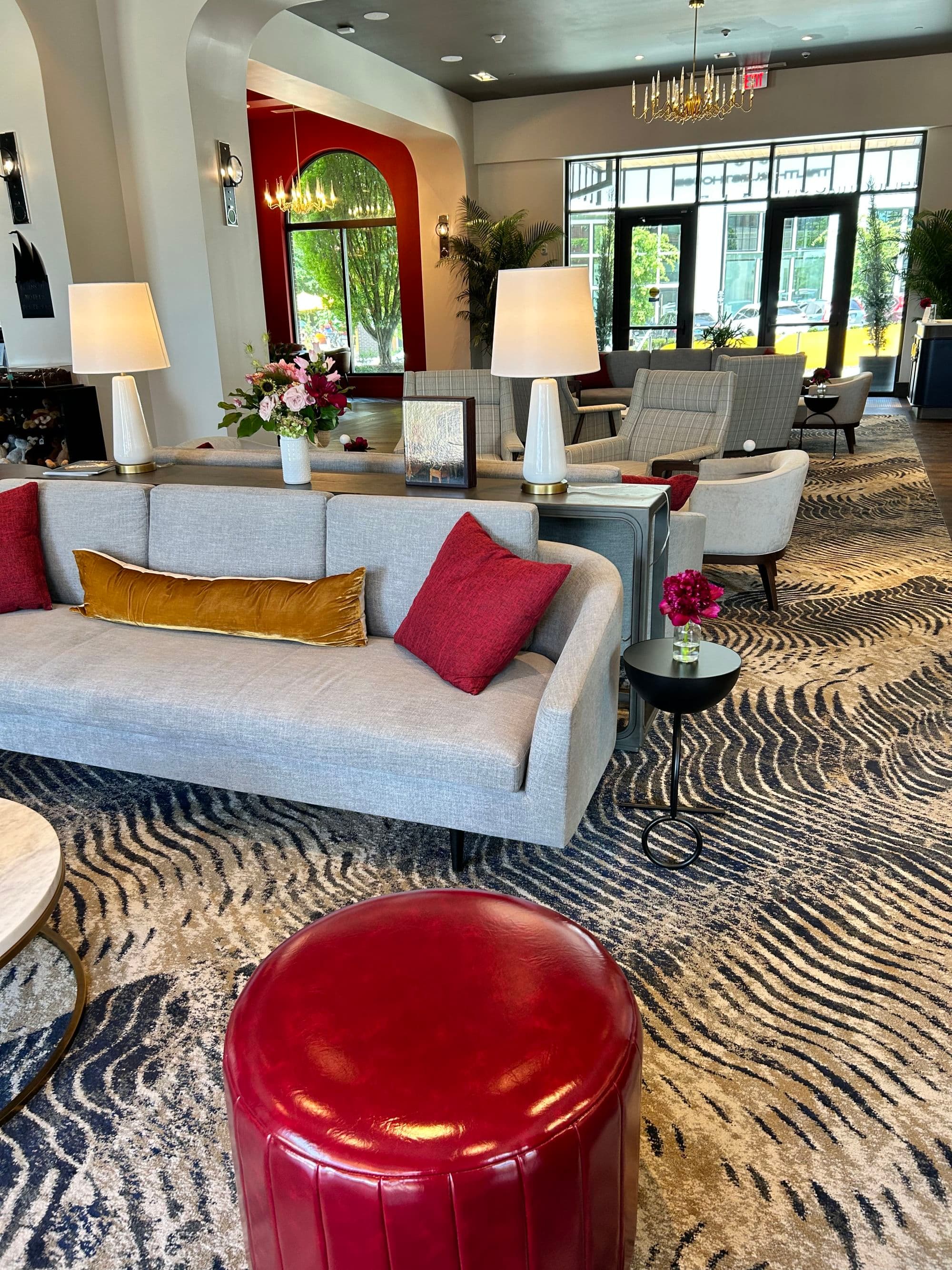 Lobby area at hotel with modern furniture and large bay windows with a view.