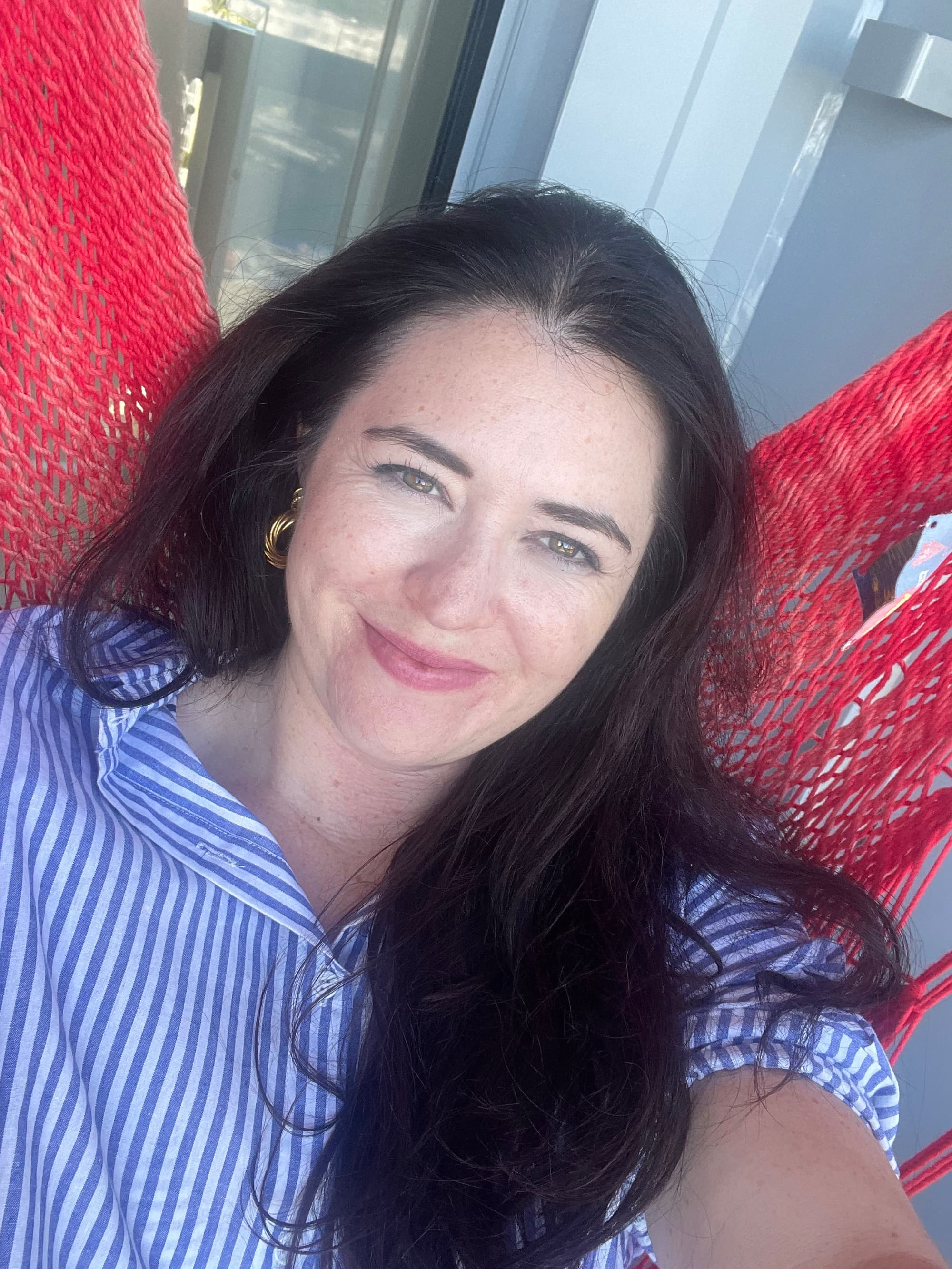 Travel advisor Jacqueline posing on a red hammock.