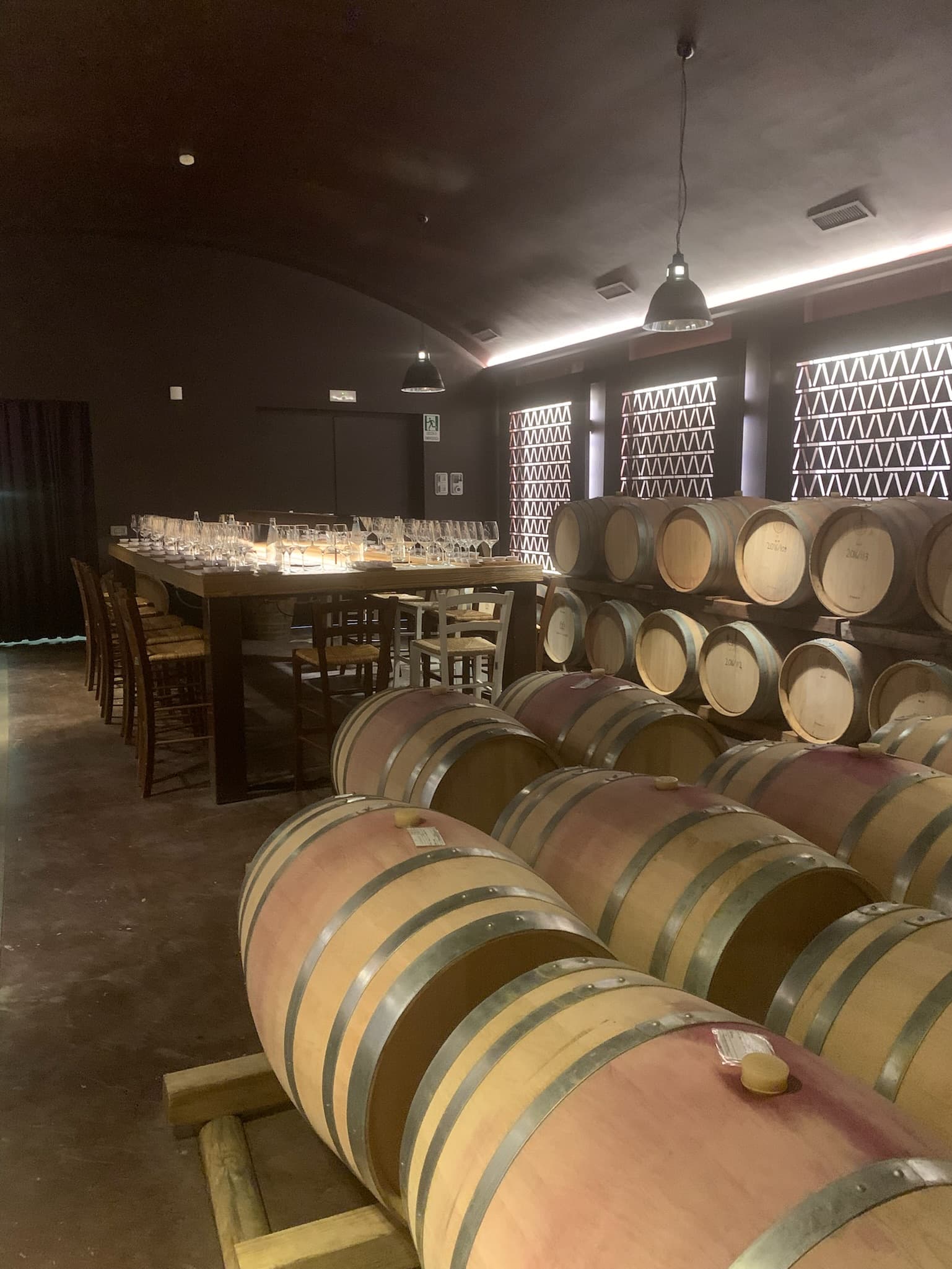 Wine Cellar at Castelfalfi with many barrels and a dining table setup.