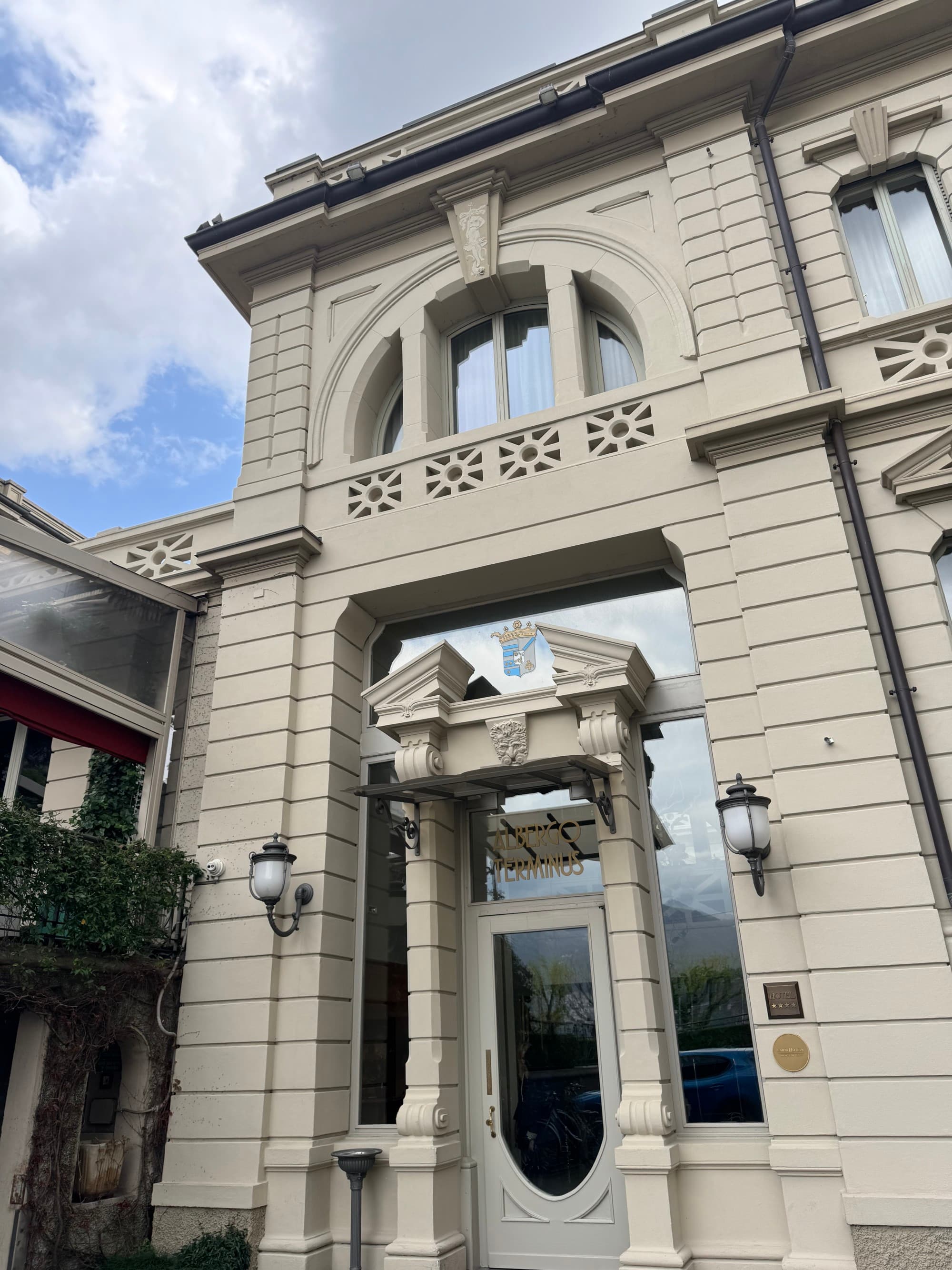 The entrance to the hotel, a small glass and wooden door in between a tan, stone facade.