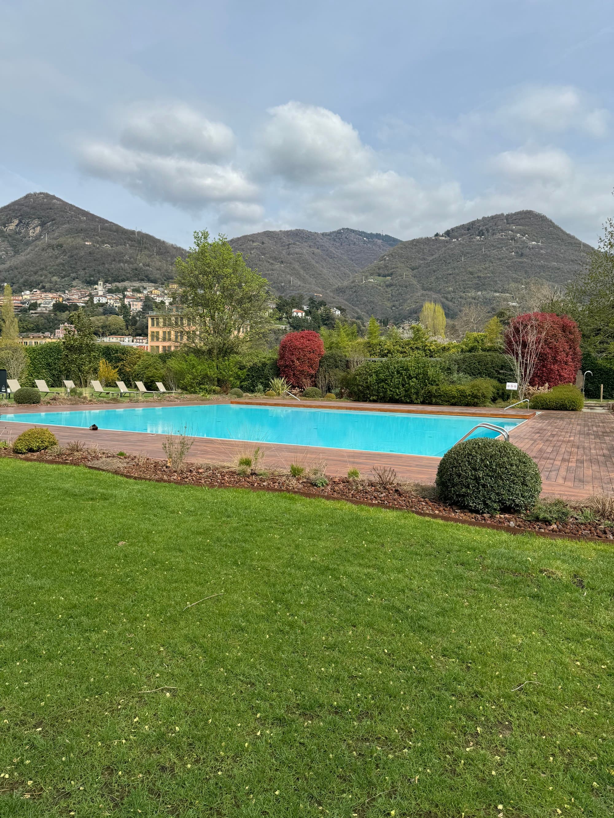 An outdoor pool with lush green mountain ranges in the background.