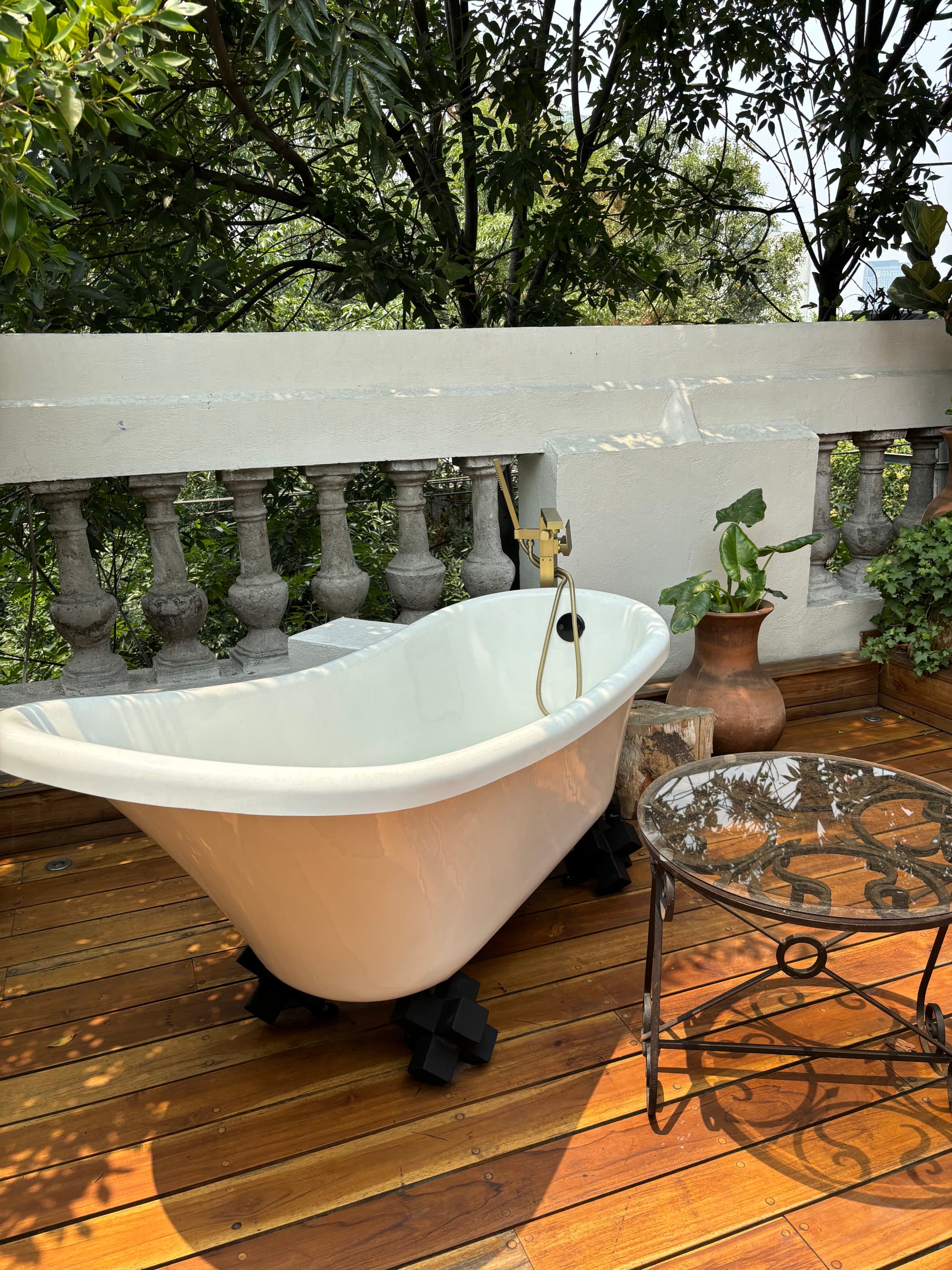 A white, clawfoot bathtub on an outside balcony